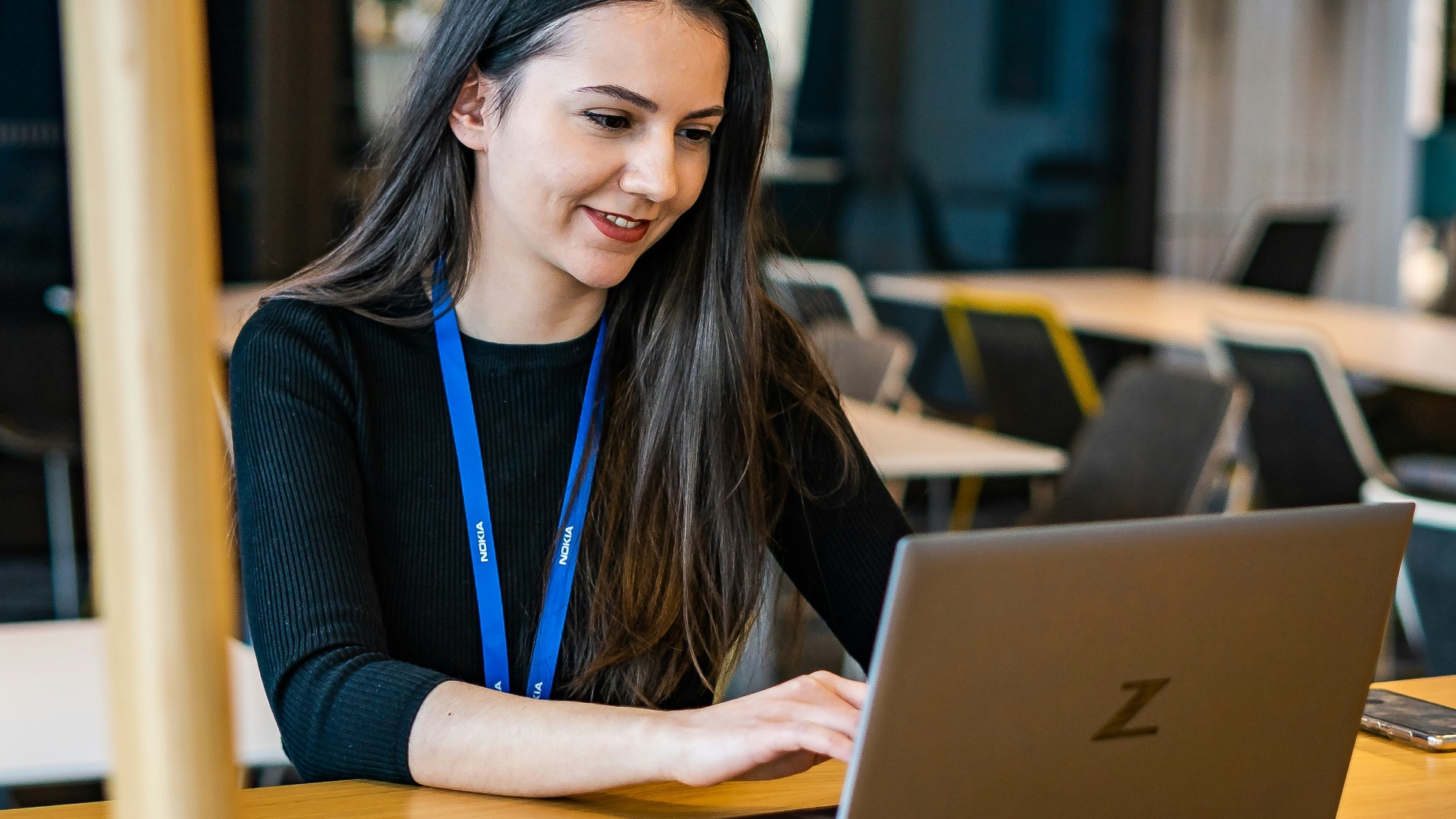a woman sitting at a table using a laptop computer