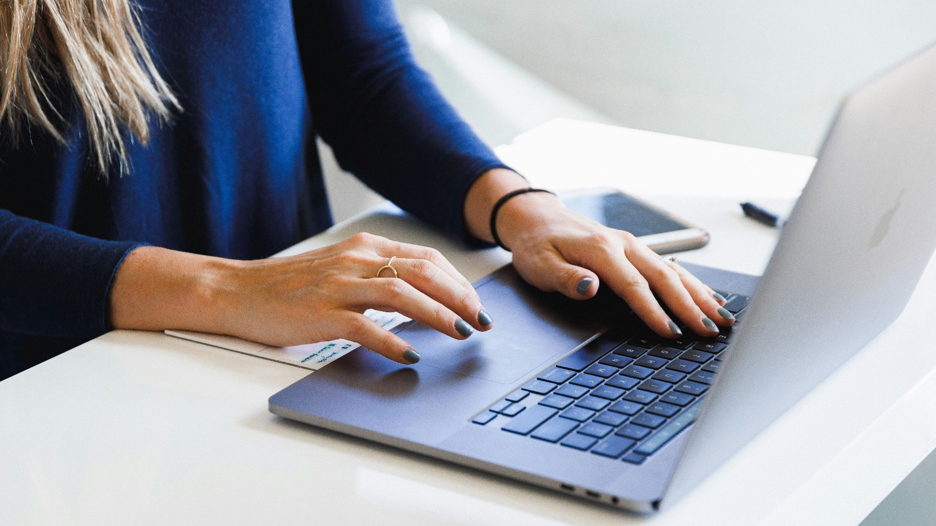 woman in blue long sleeve shirt using macbook pro