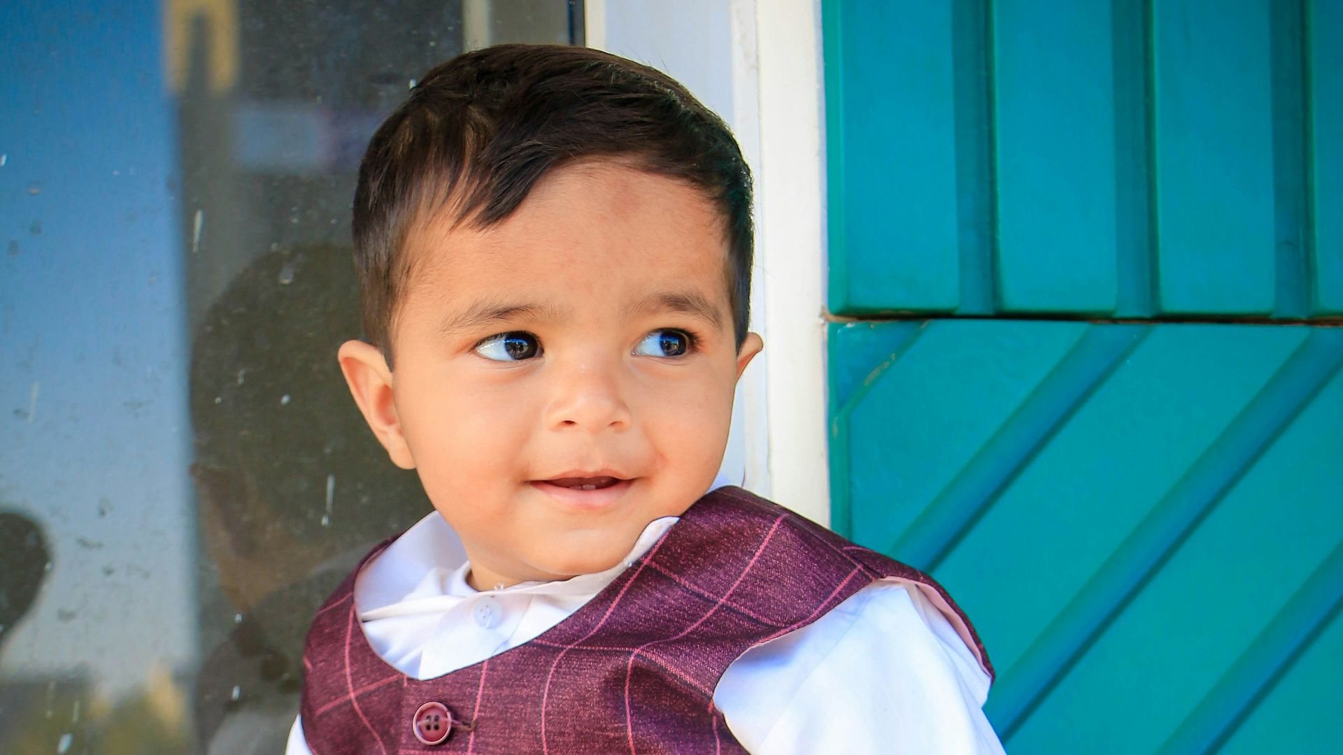 a little boy sitting on a window sill