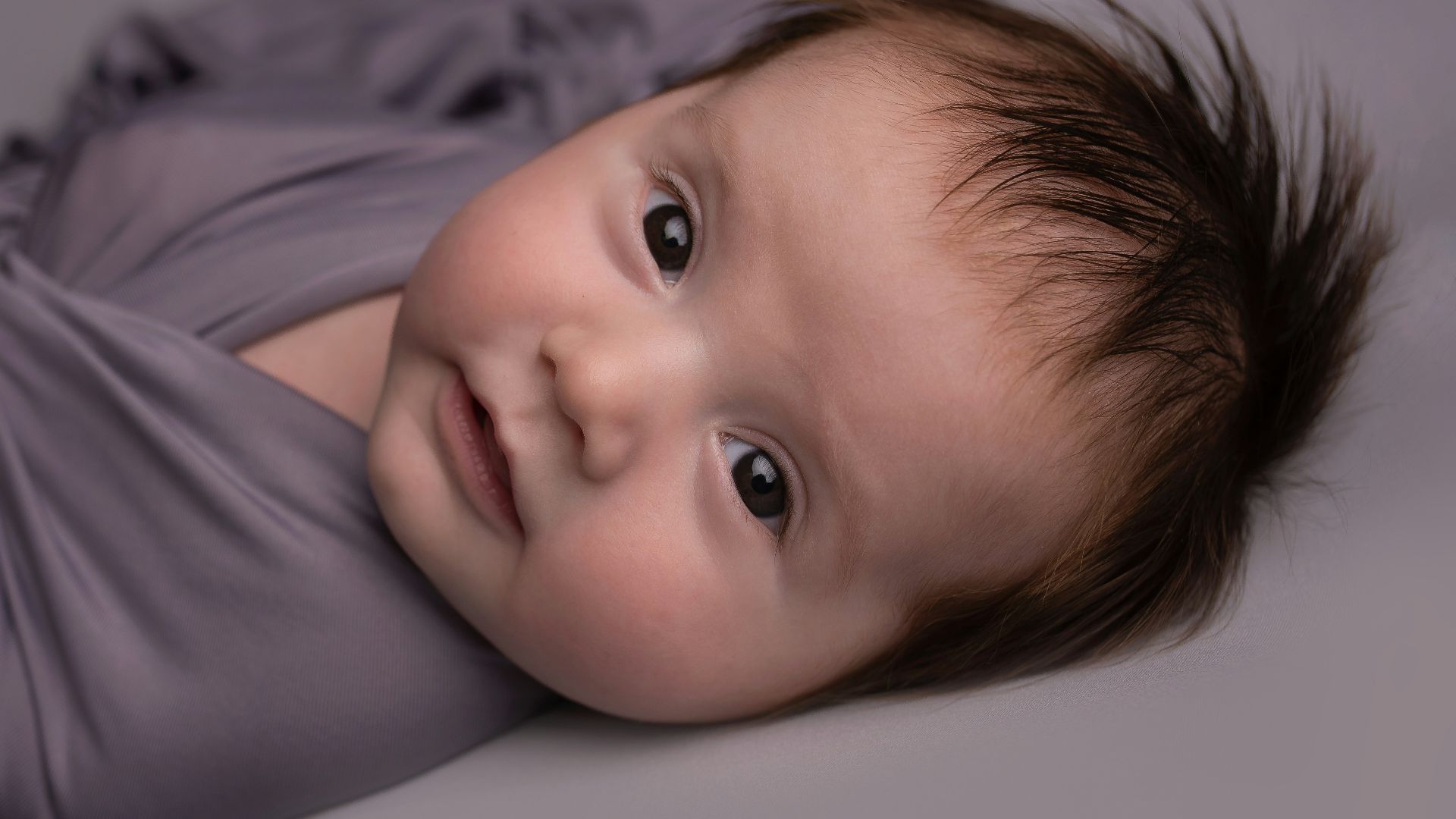 baby in white shirt lying on bed