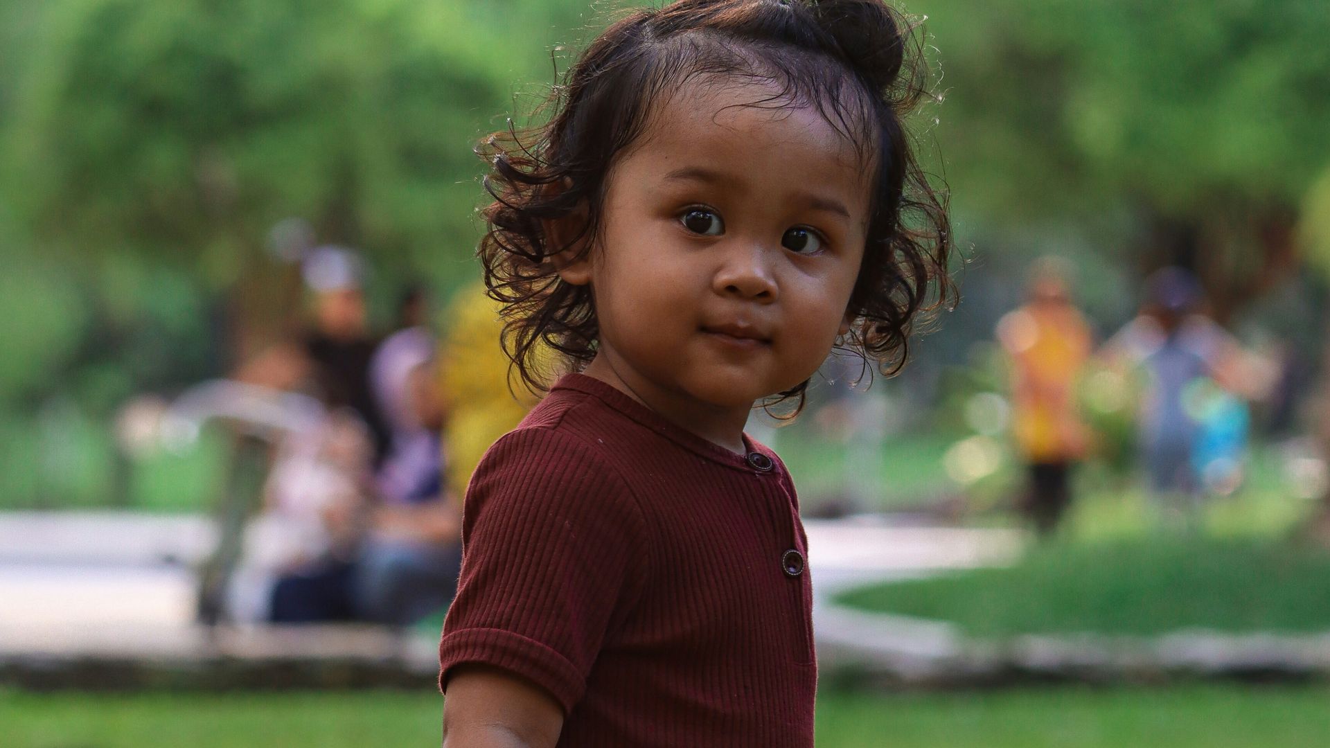 a little girl standing in the grass with a frisbee