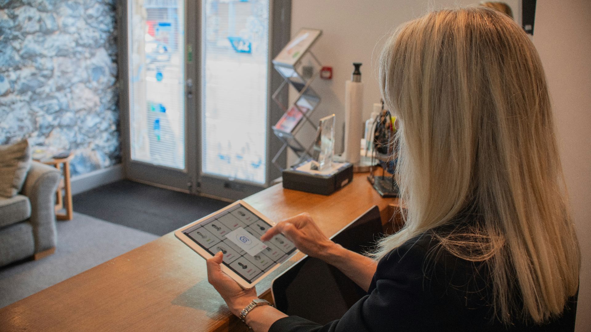 Woman using a tablet at a reception desk.
