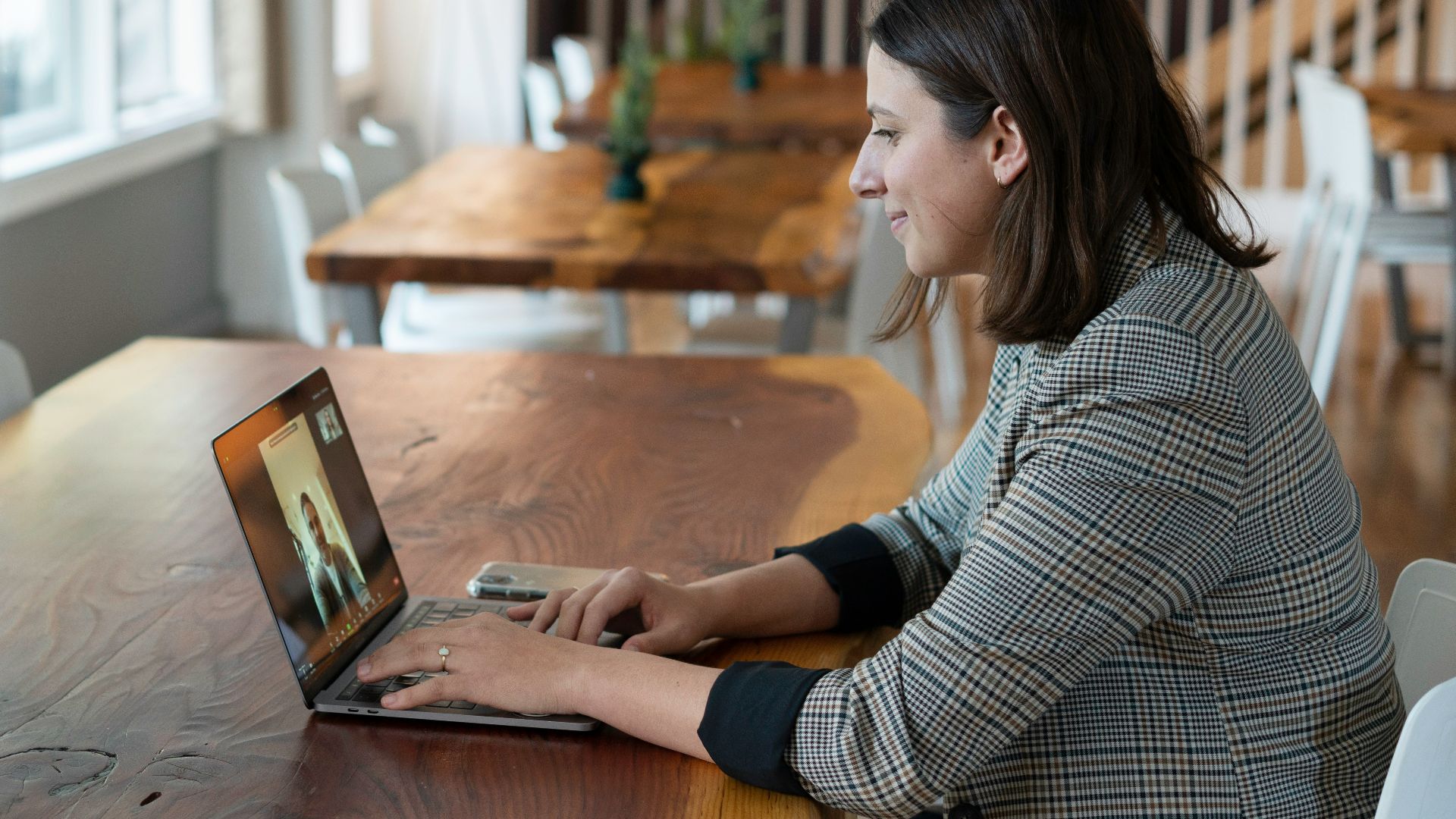 woman in gray and white striped long sleeve shirt using silver macbook