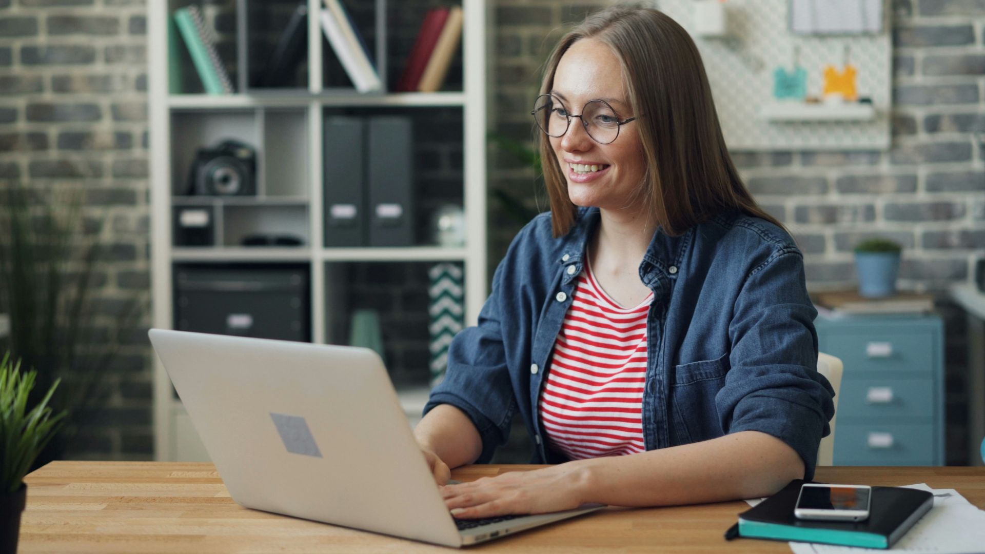 a woman sitting at a table using a laptop computer