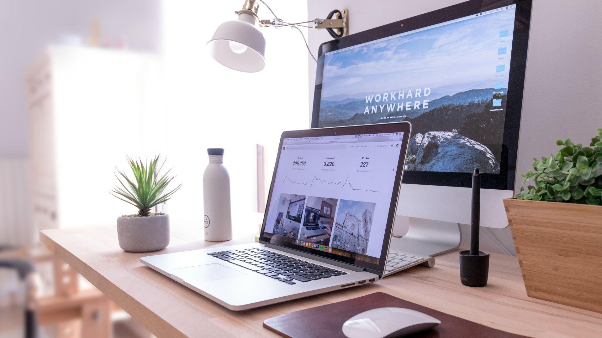 MacBook Pro on table beside white iMac and Magic Mouse