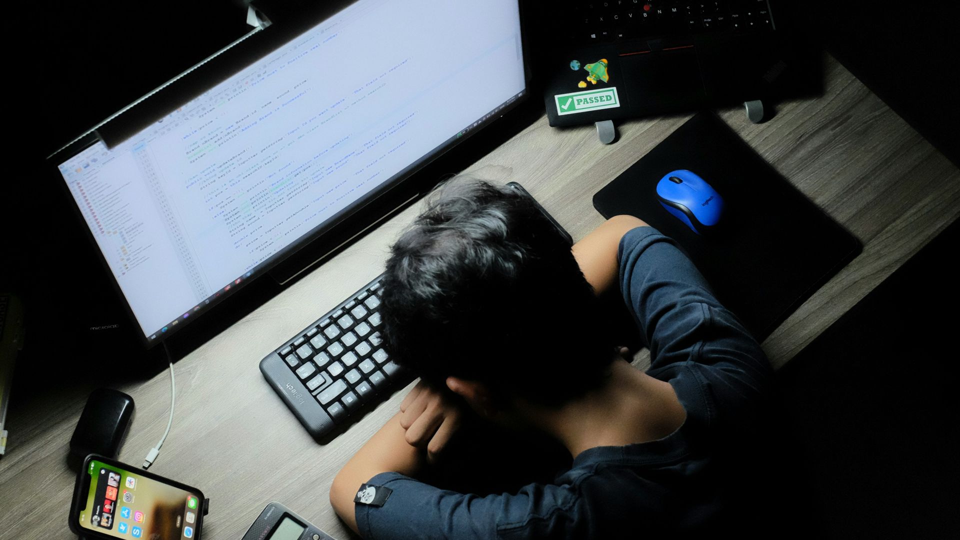 a man sitting in front of a computer monitor