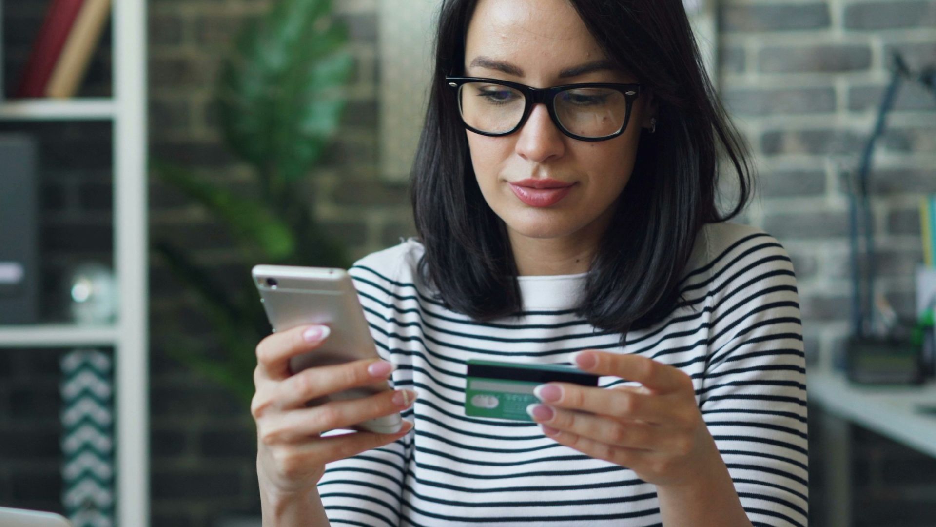 a woman sitting at a table looking at her cell phone