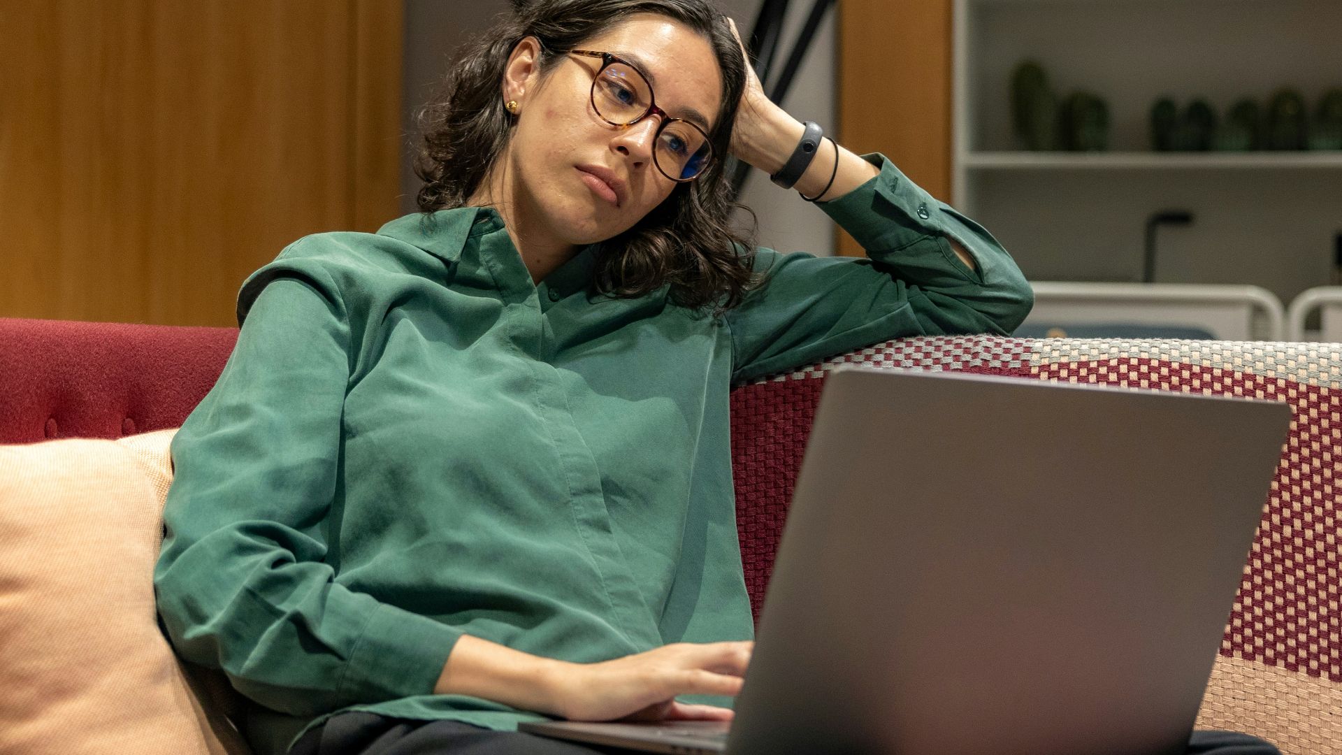 a woman sitting on a couch using a laptop computer