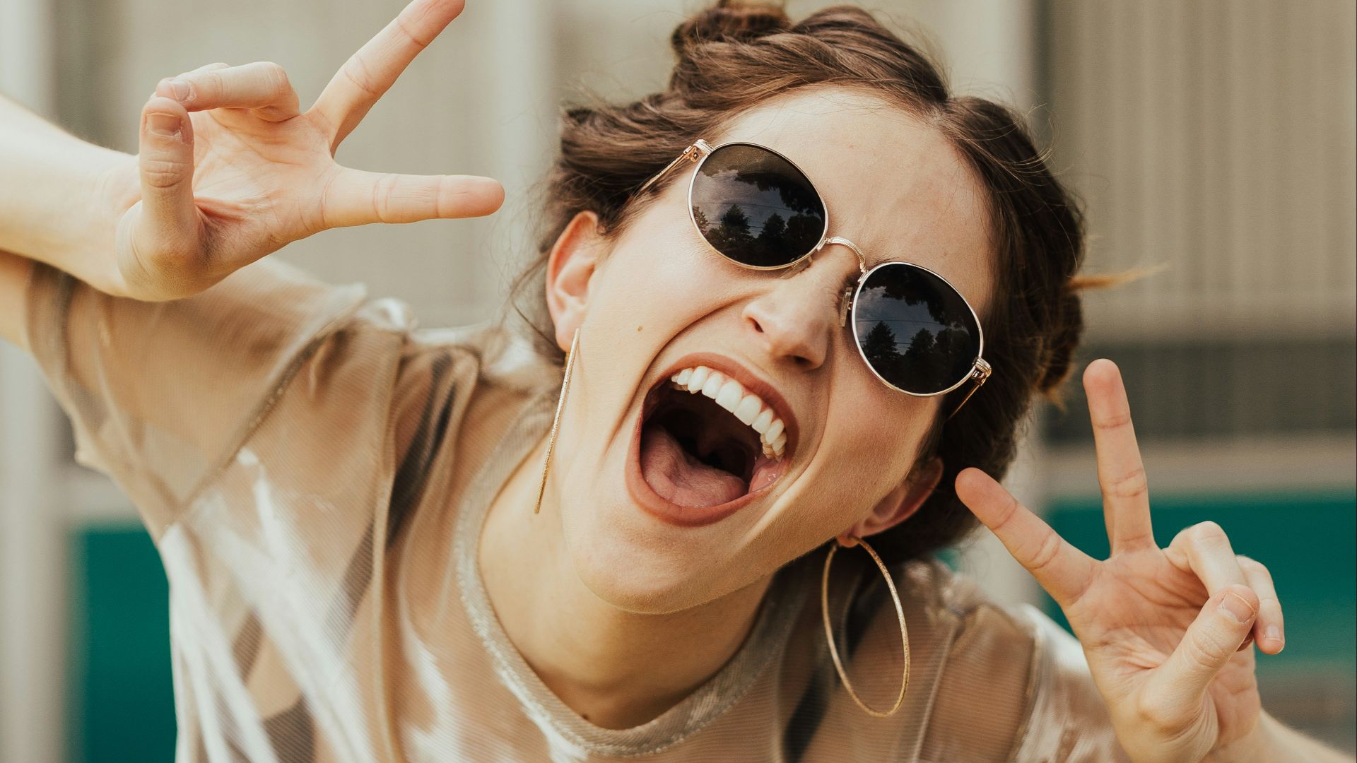 selective focus photography of jolly woman using peace hand gesture
