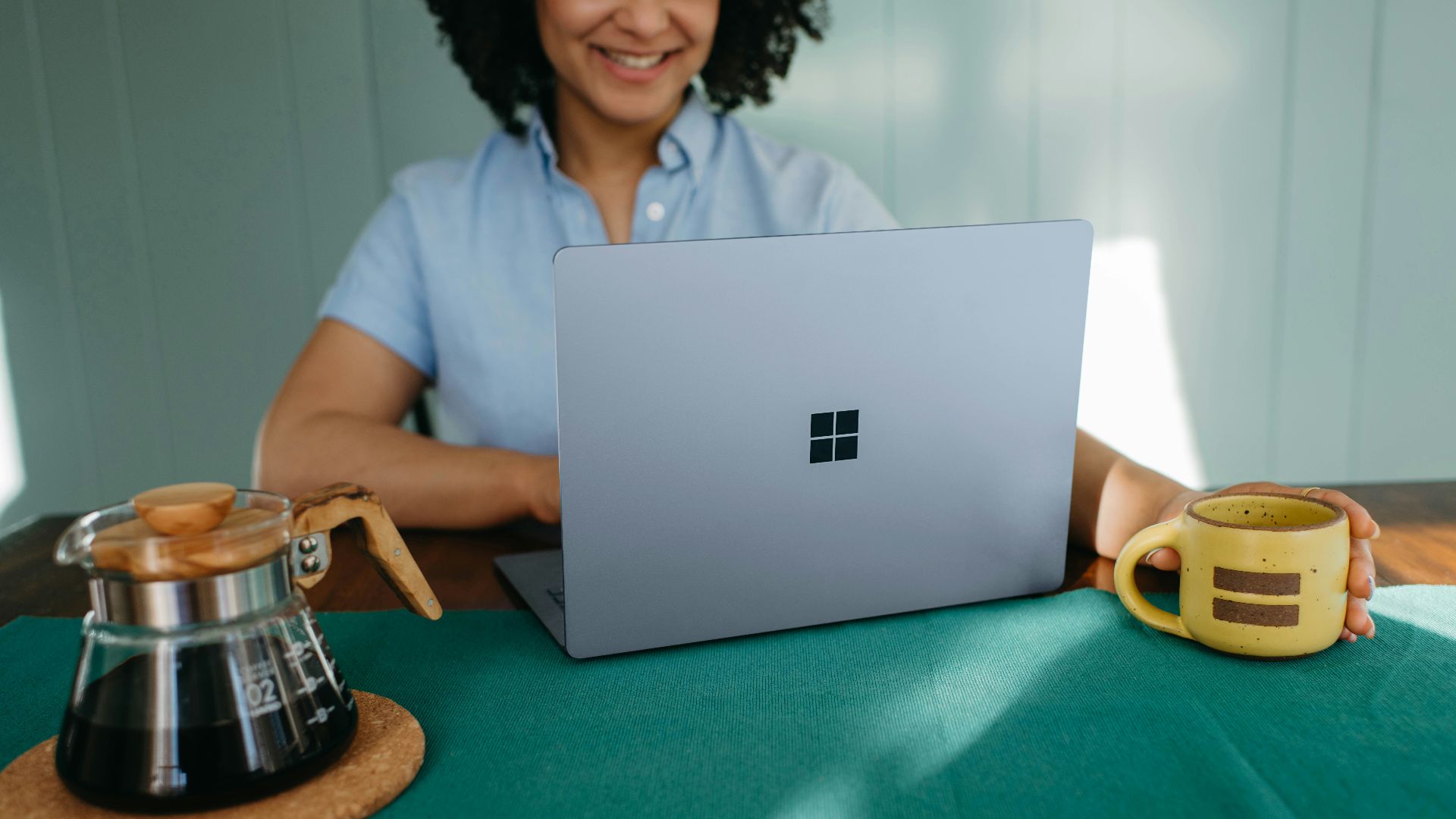 a woman sitting at a table with a laptop