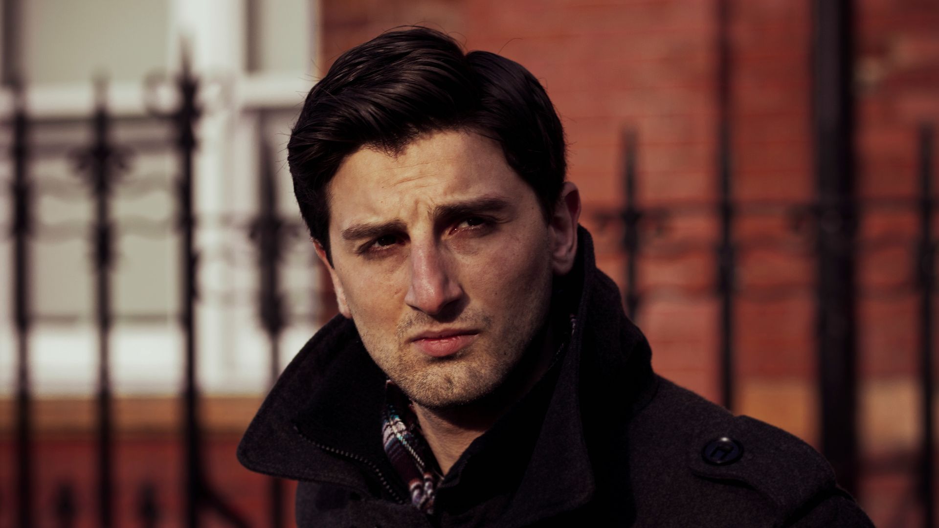 a man standing in front of a fence