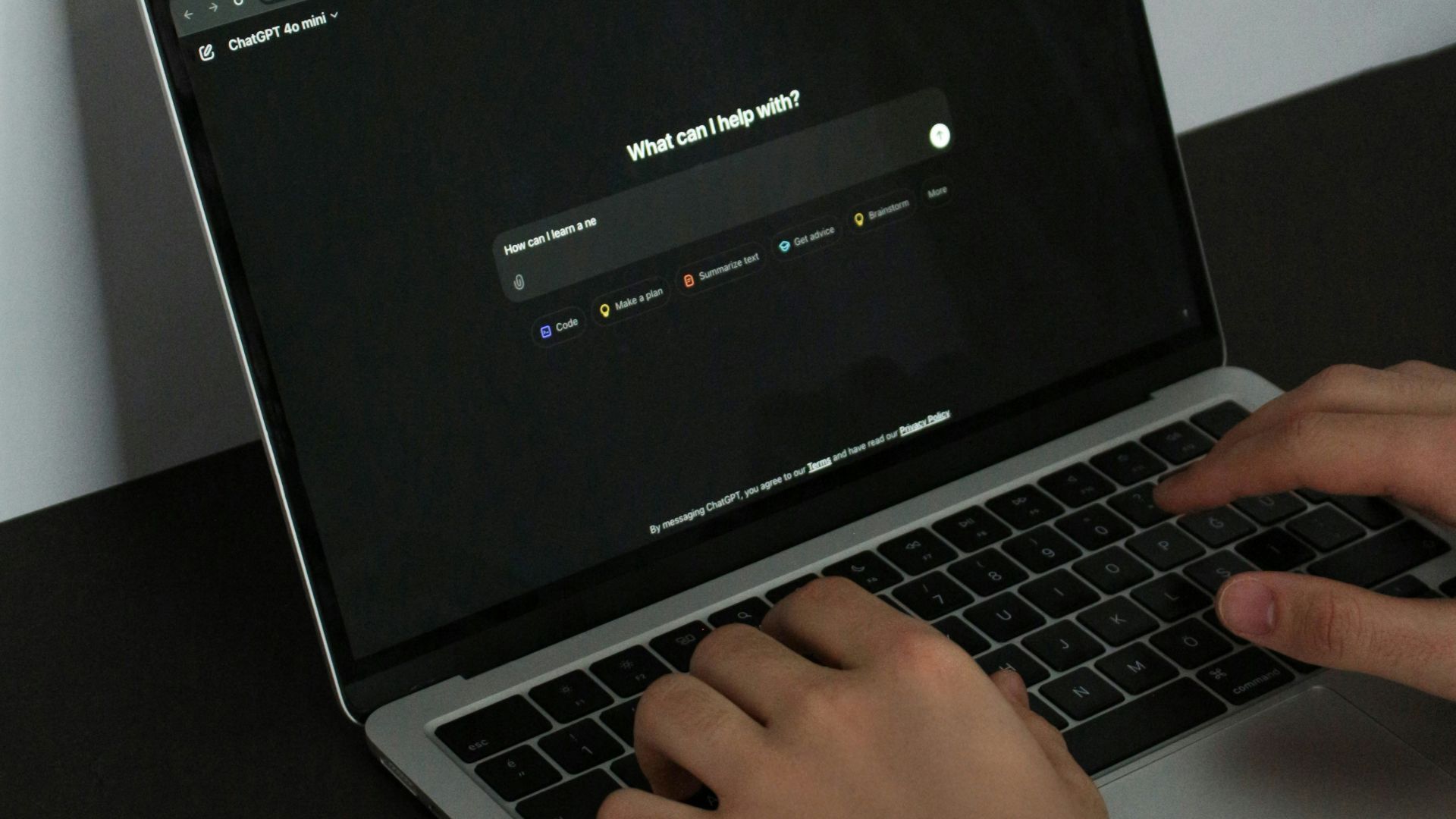 A person typing on a laptop on a table