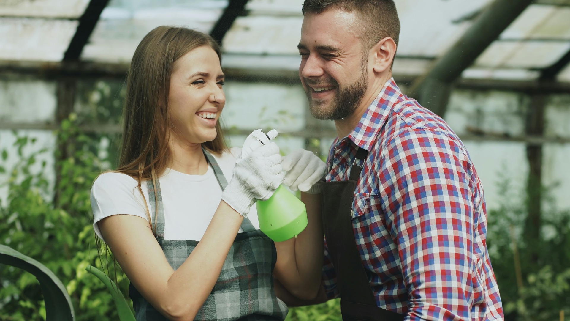 Couple high-fiving while working in a greenhouse.