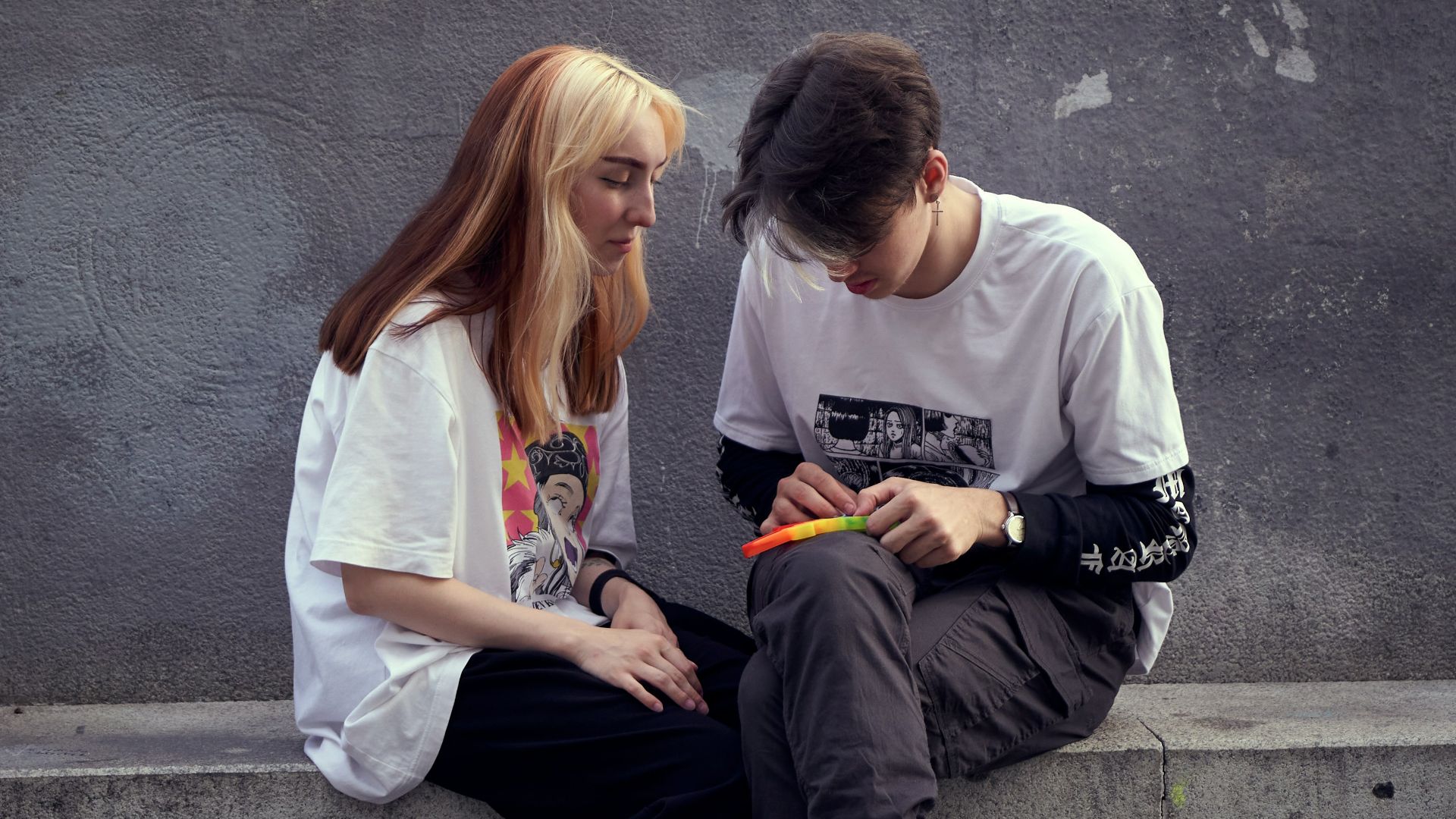 man in white crew neck t-shirt sitting beside woman in white crew neck t-shirt