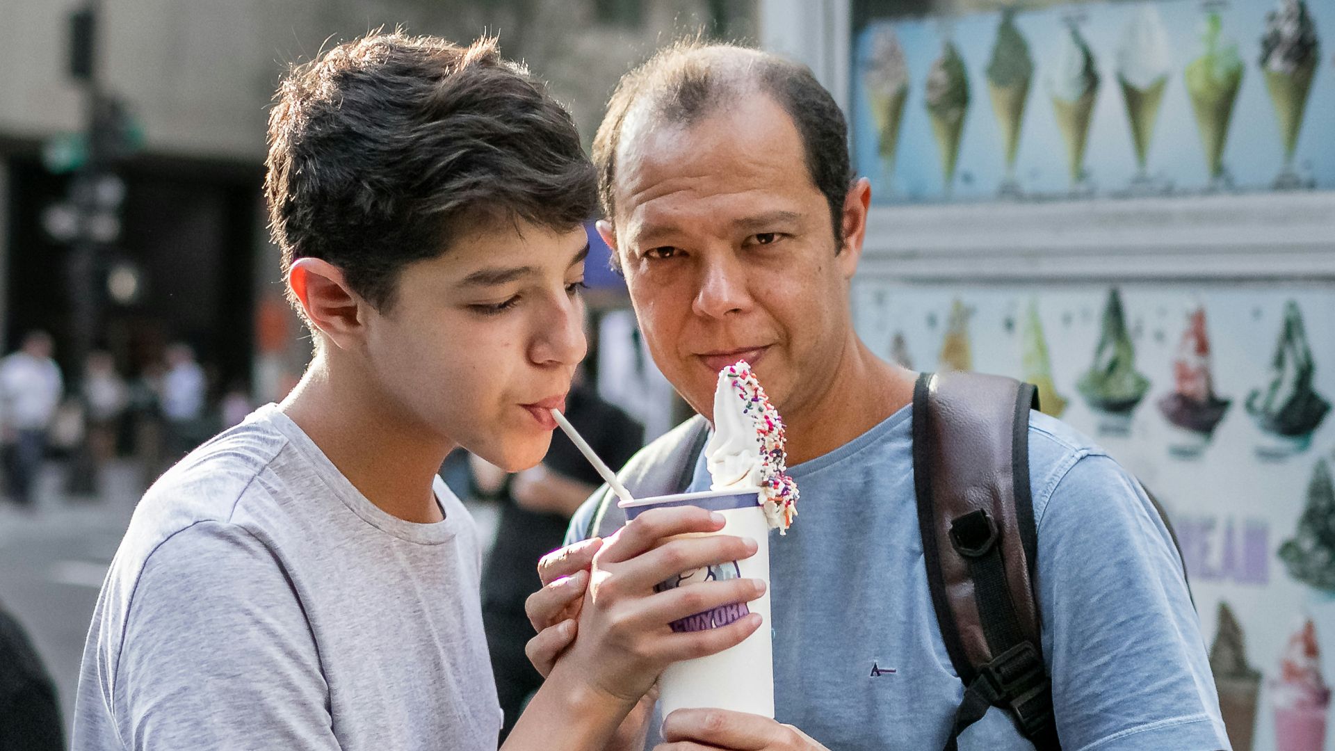 a person holding a drink and another man holding a cup