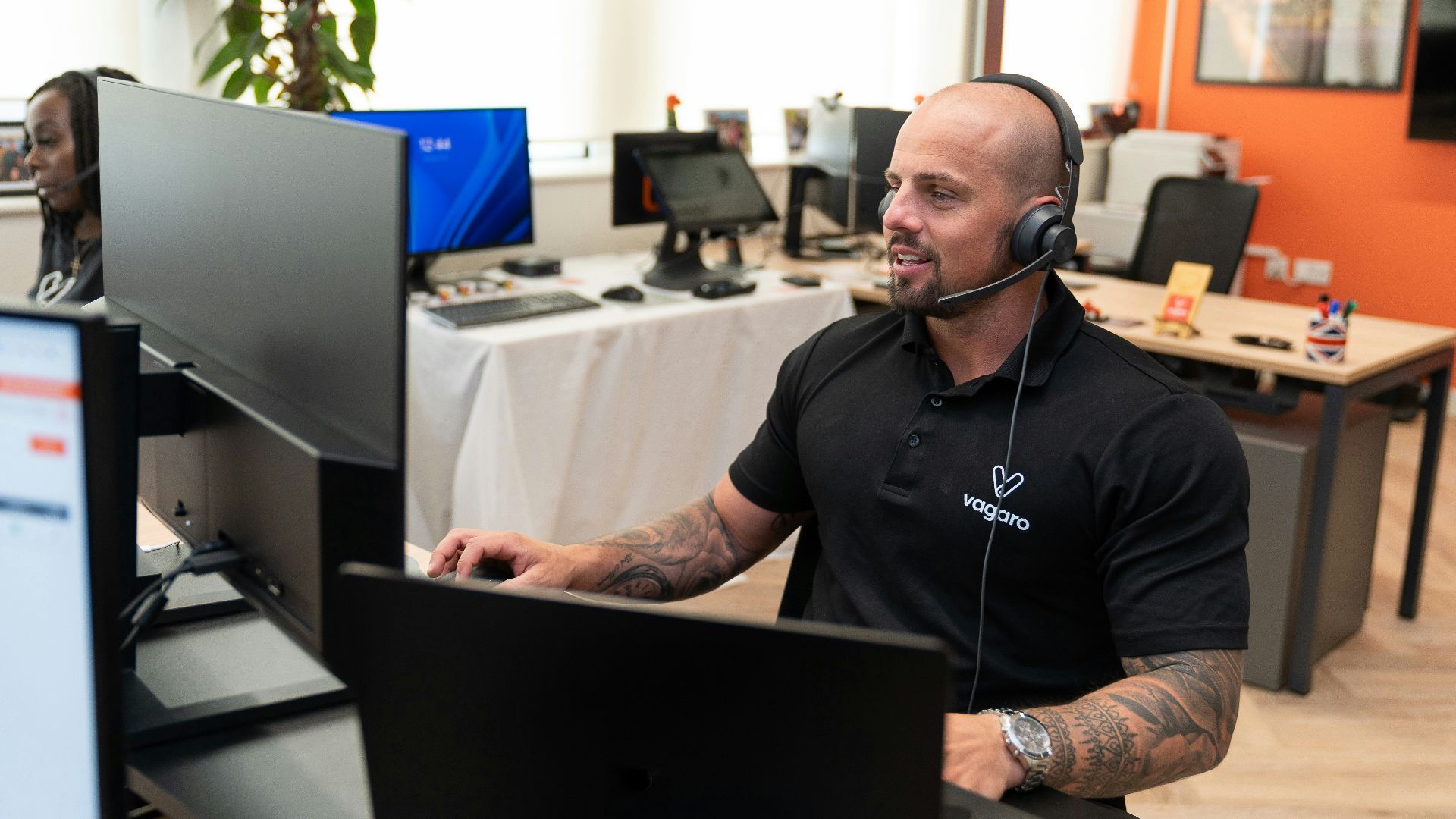 a man wearing a headset sitting in front of a computer