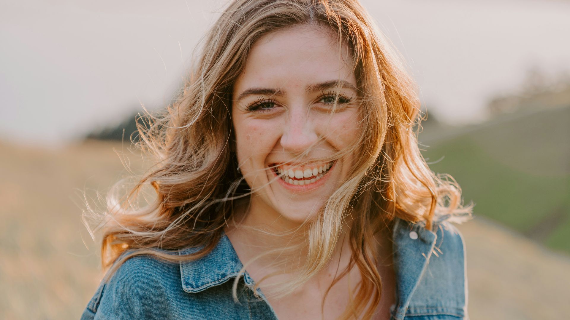 smiling woman sitting on grass during daytime