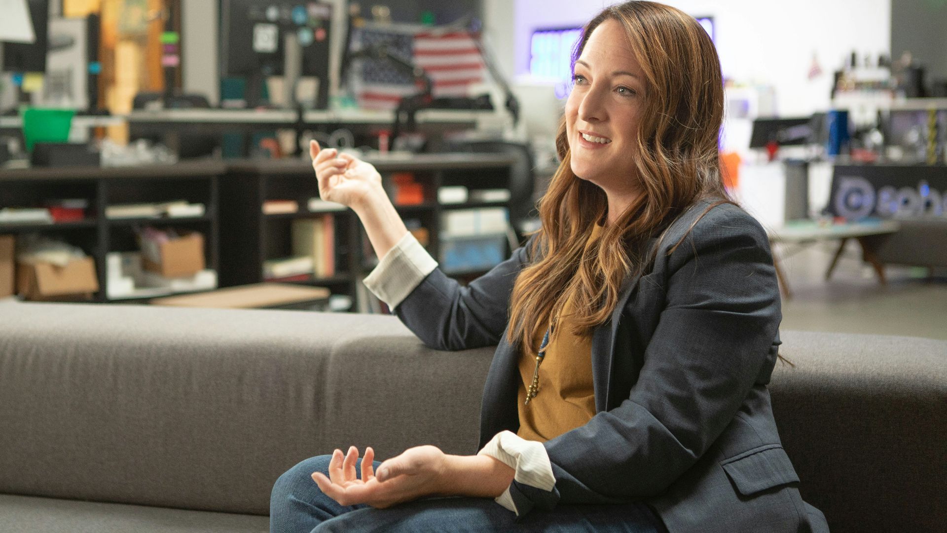 woman in black blazer sitting on gray couch