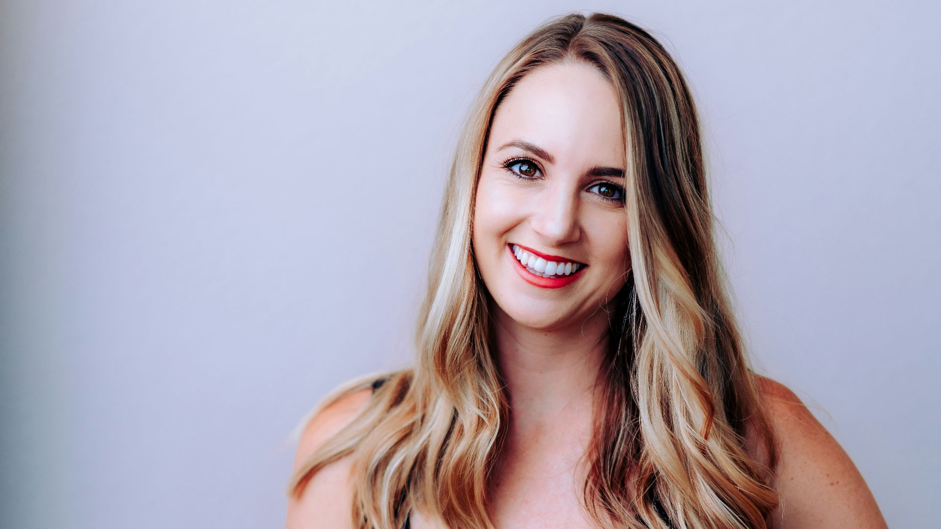 woman in black tank top smiling