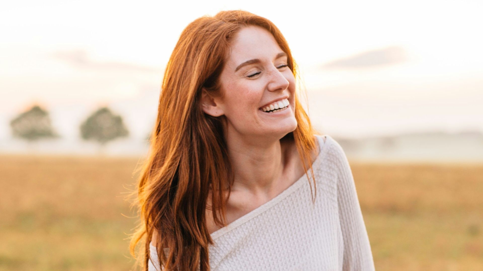 woman in white long sleeve shirt and blue denim jeans standing on green grass field during