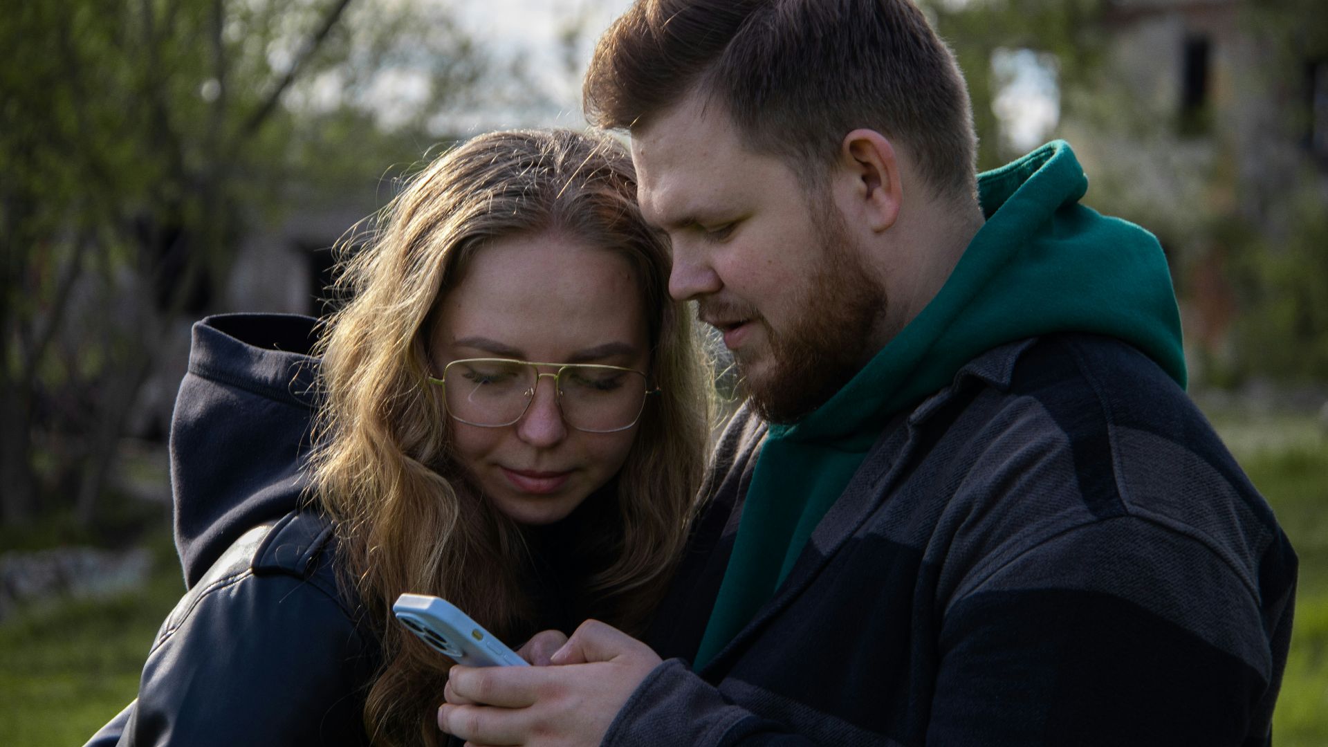 a man and a woman looking at a cell phone