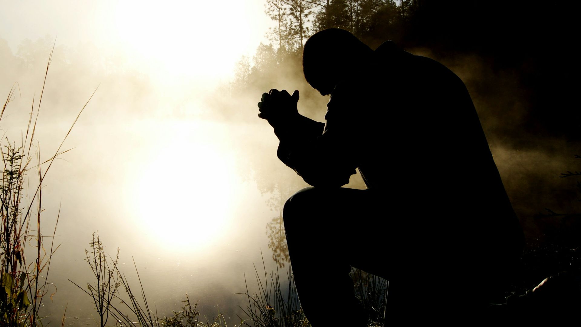 silhouette of kneeling man