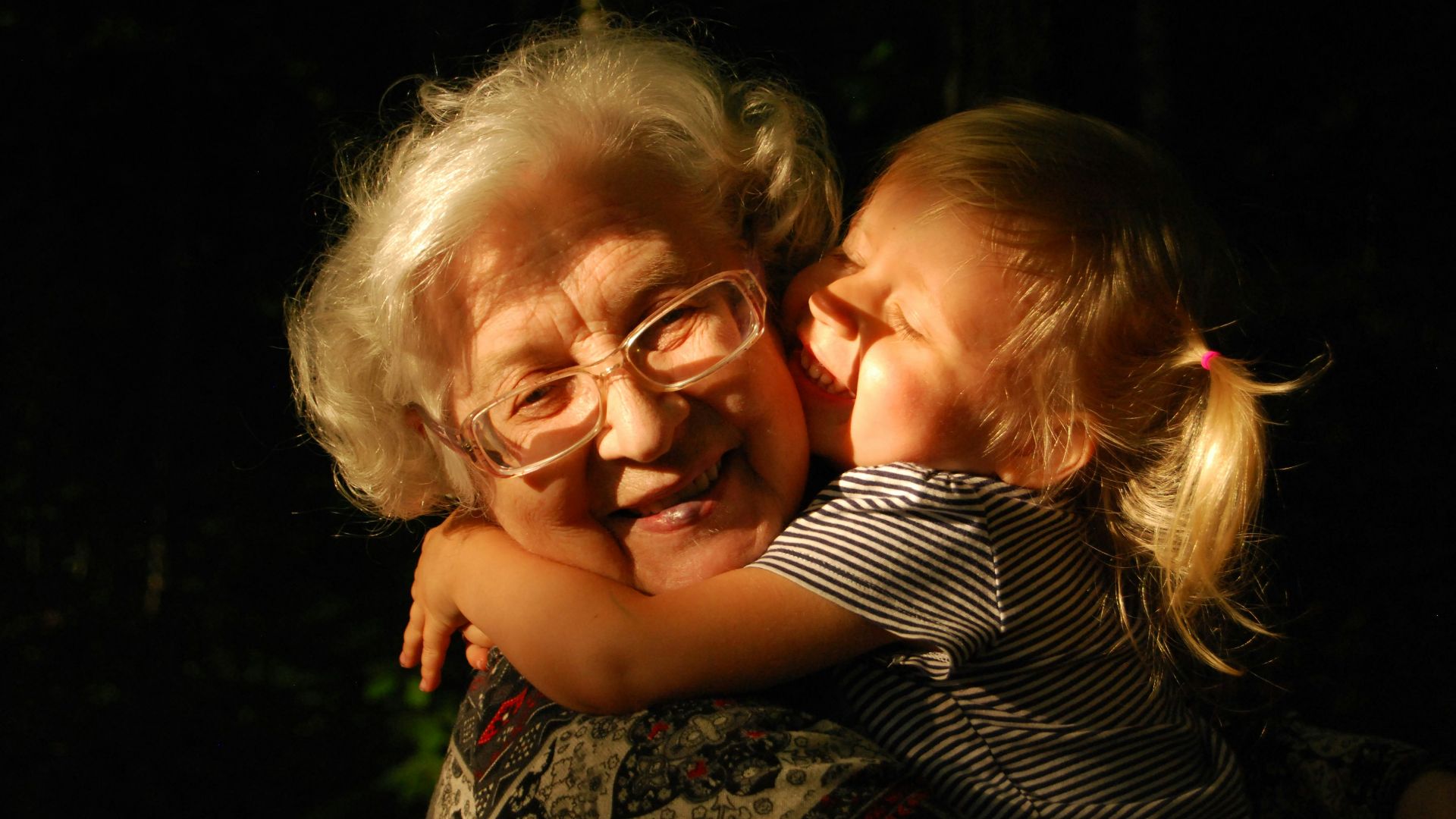 woman in black and white striped shirt hugging girl in black and white striped shirt