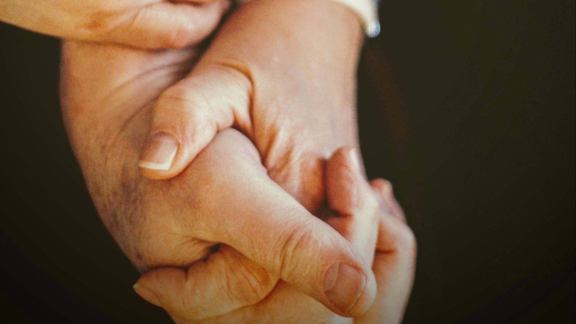 person in blue long sleeve shirt holding babys hand