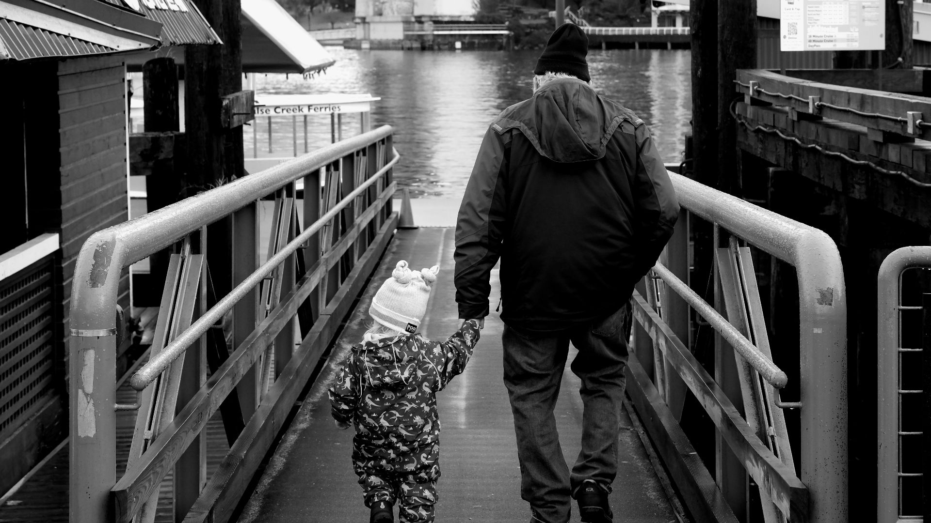 a man walking down a bridge with a child