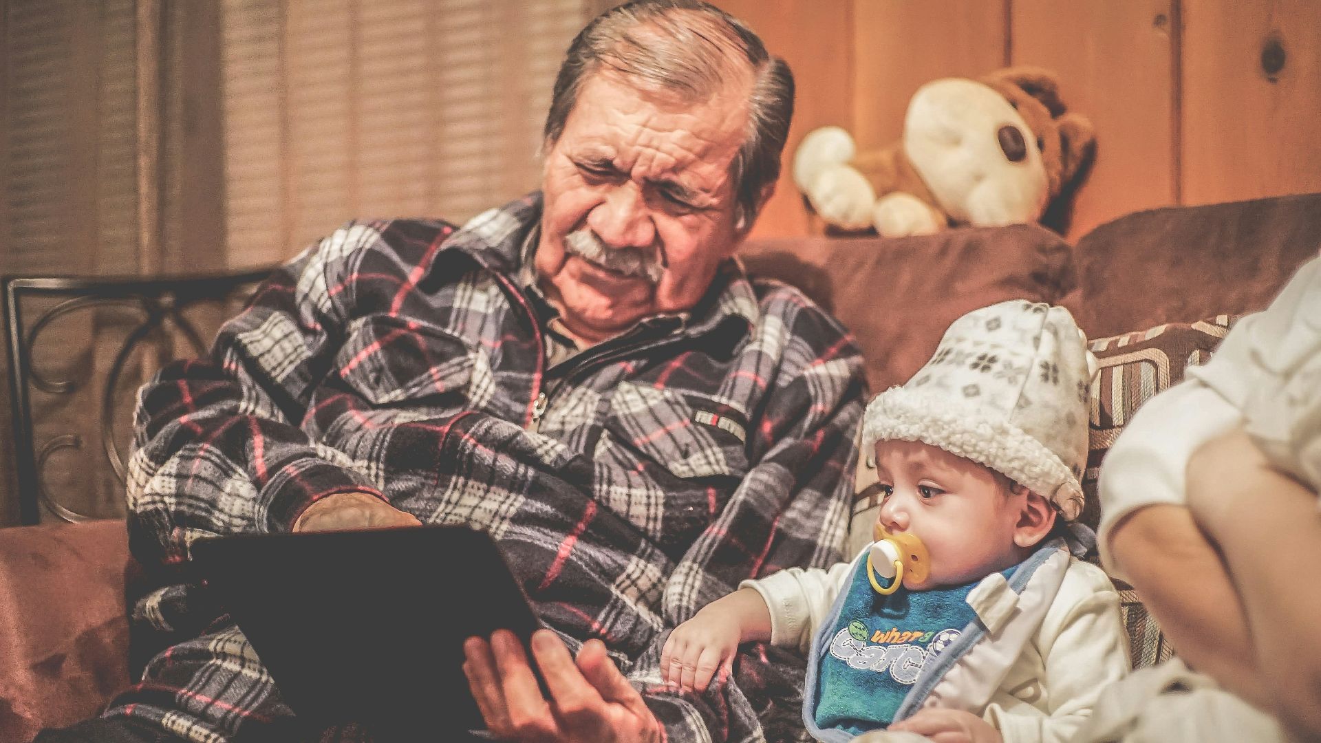 man in plaid shirt holding baby