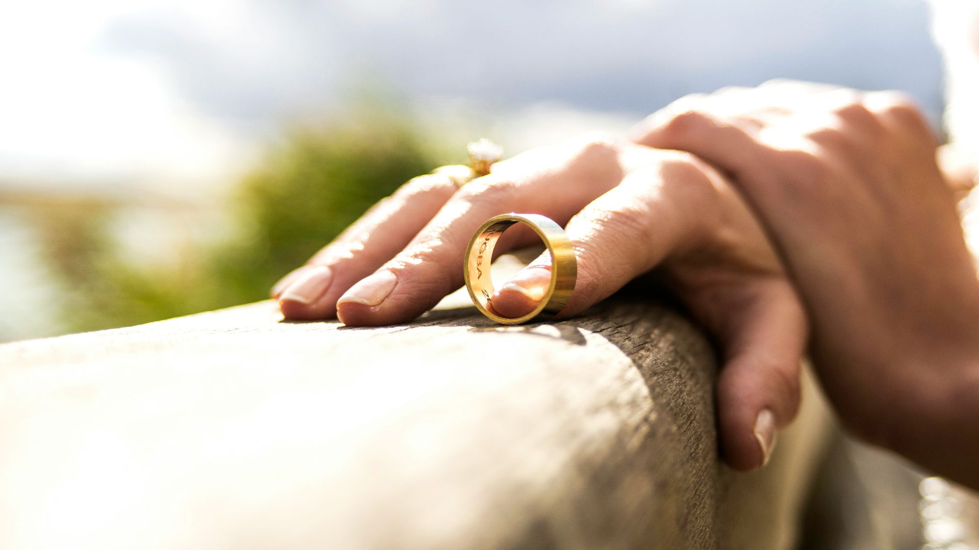 person holding gold wedding band