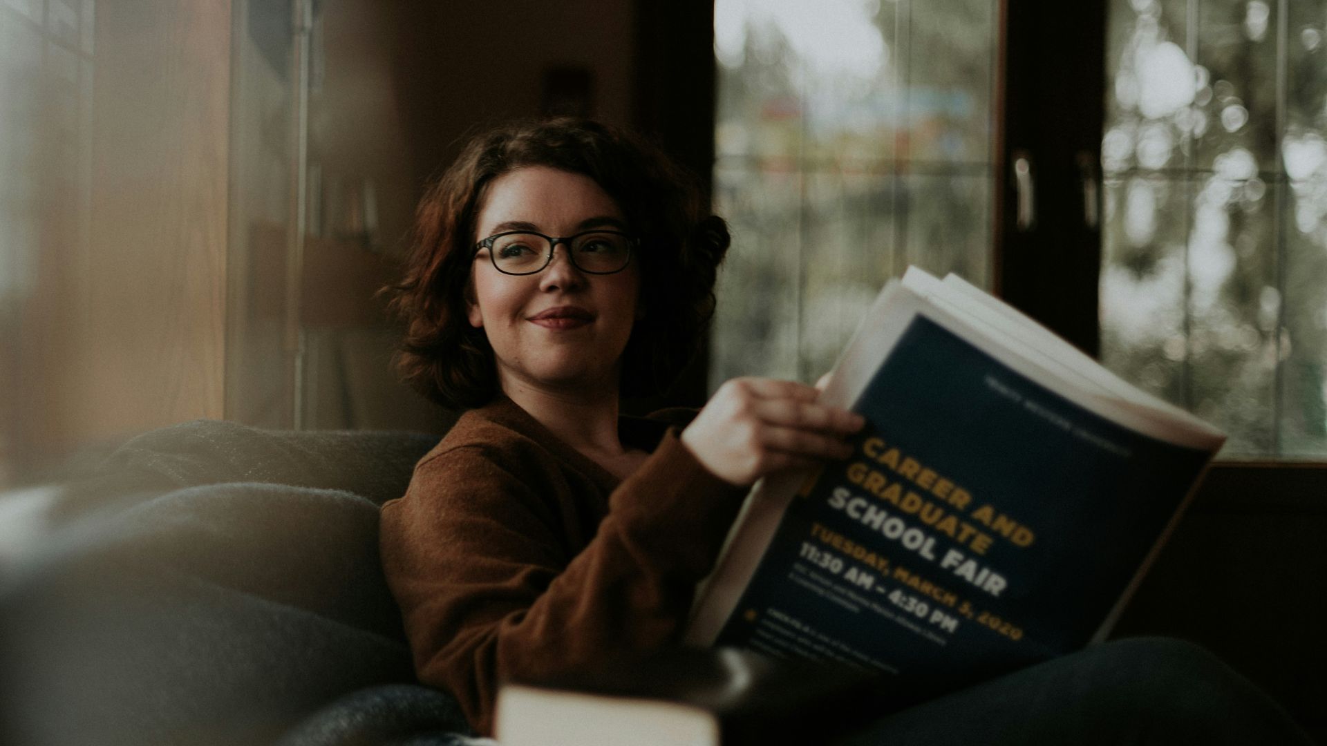 woman in brown coat using black laptop computer