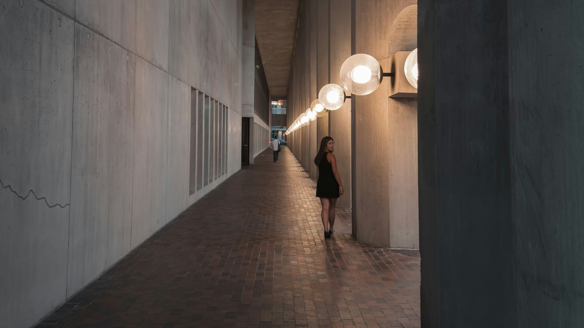 A person walking down a long hallway in a building