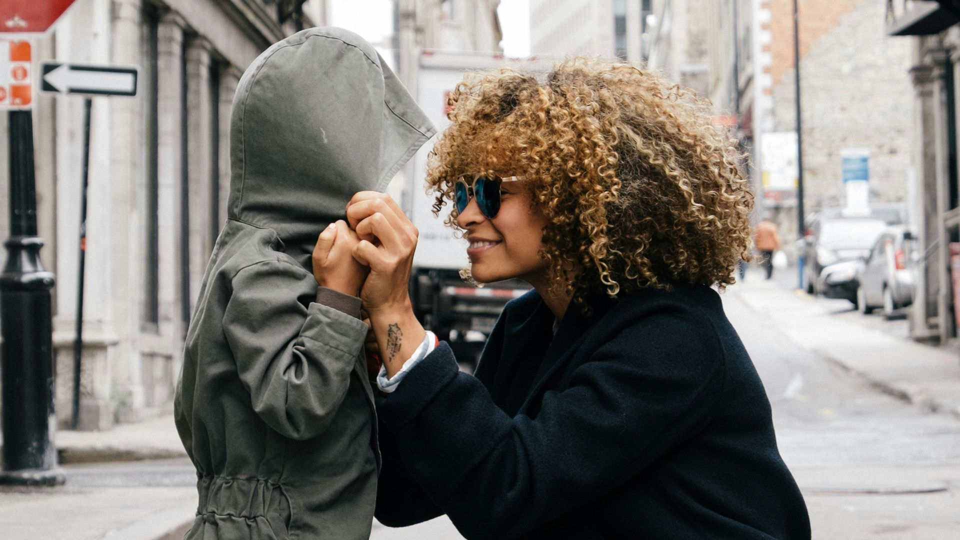 woman holding kid at the street