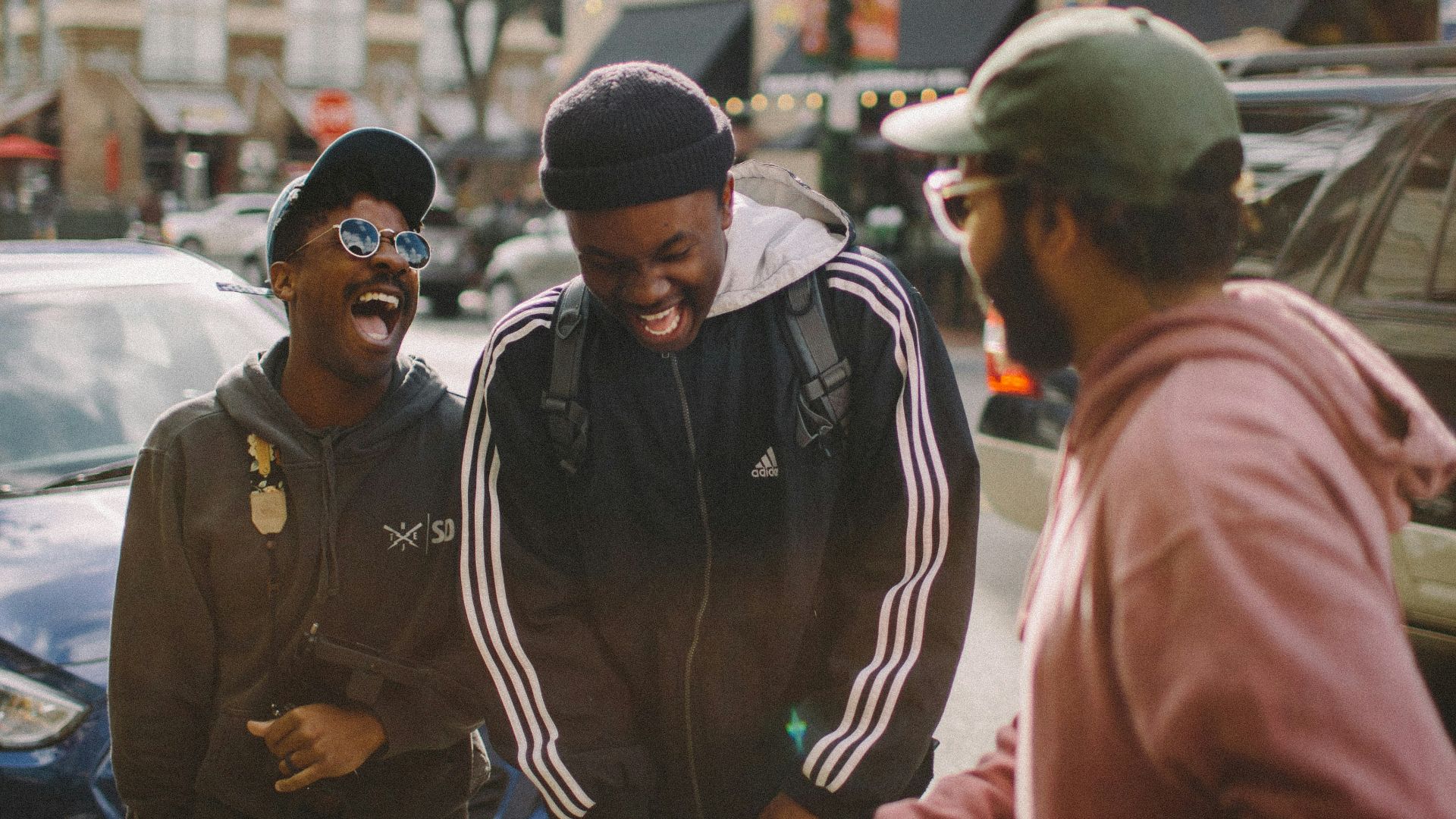three men in jacket laughing at each other