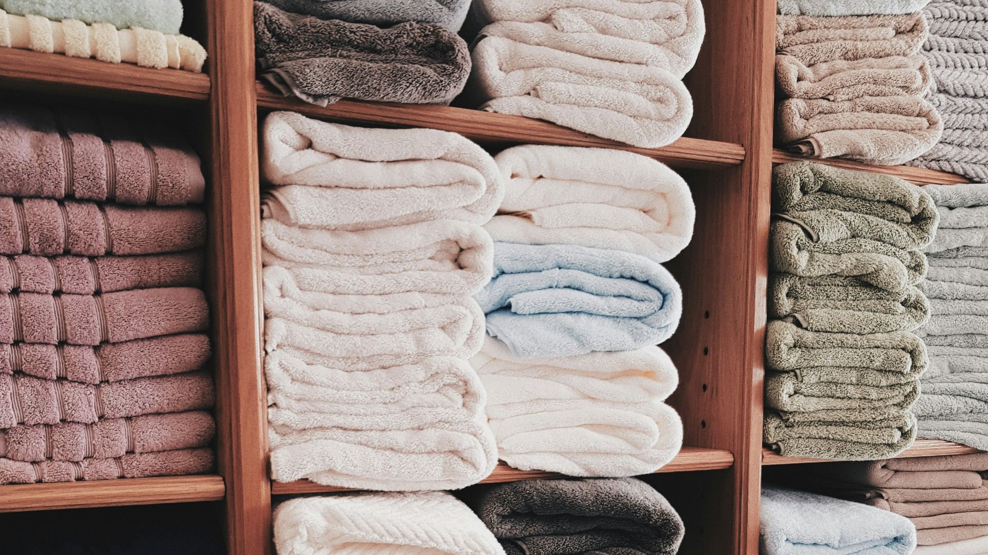 white and blue textile on brown wooden shelf