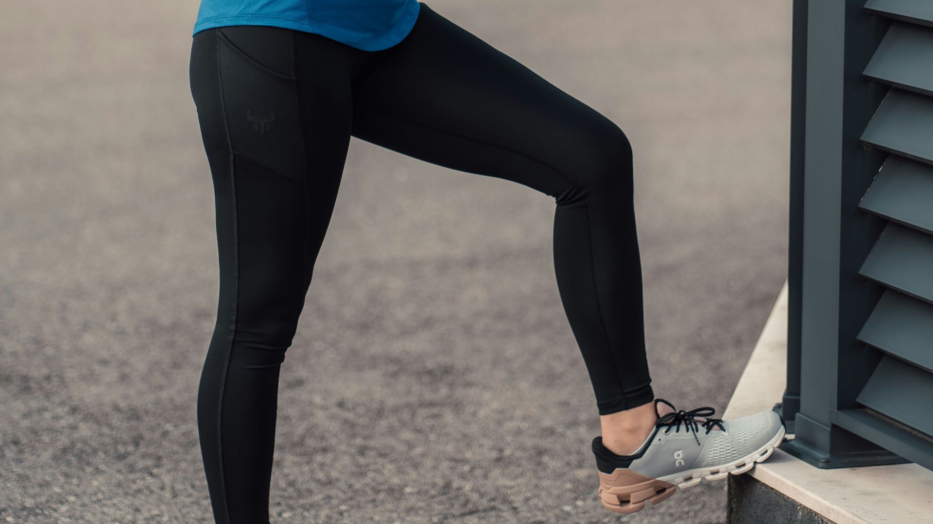 a woman in a blue jacket drinking from a cup