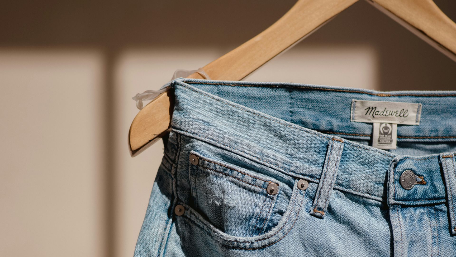 blue denim jeans on brown clothes hanger