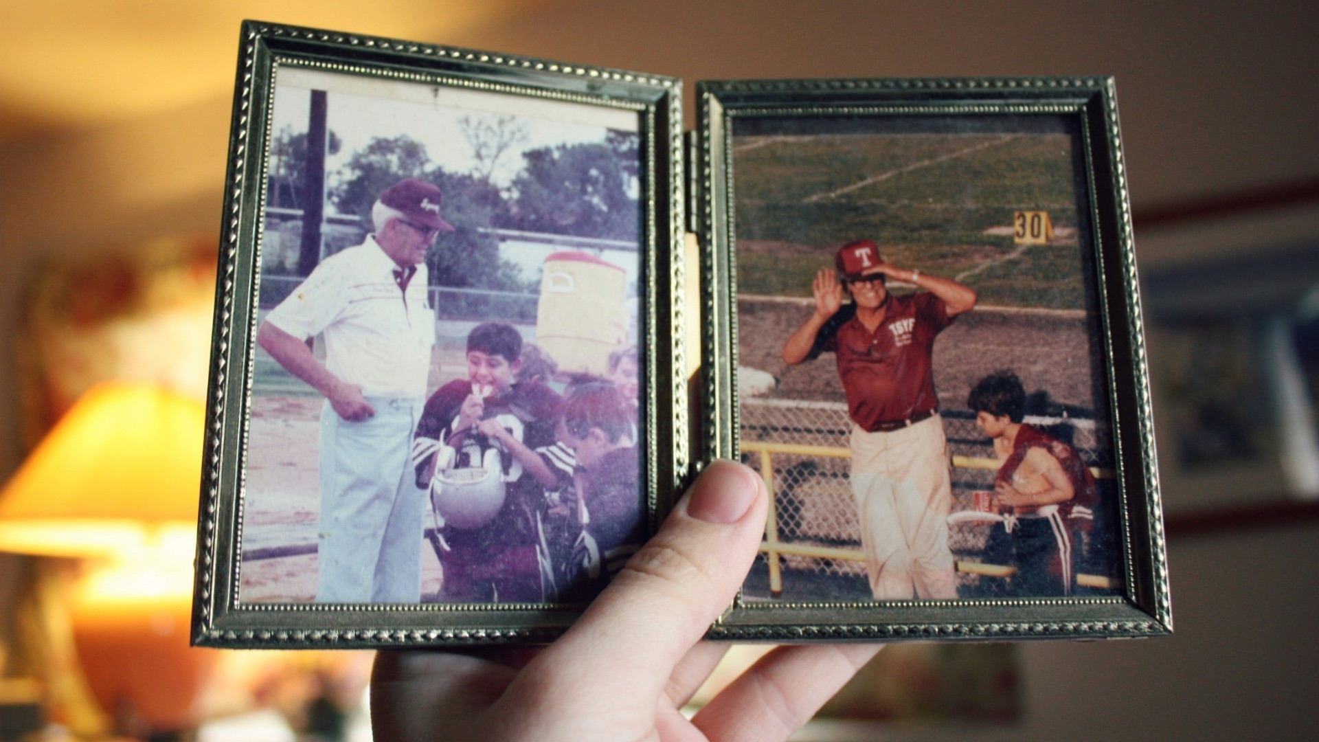 person holding two father and son photographs