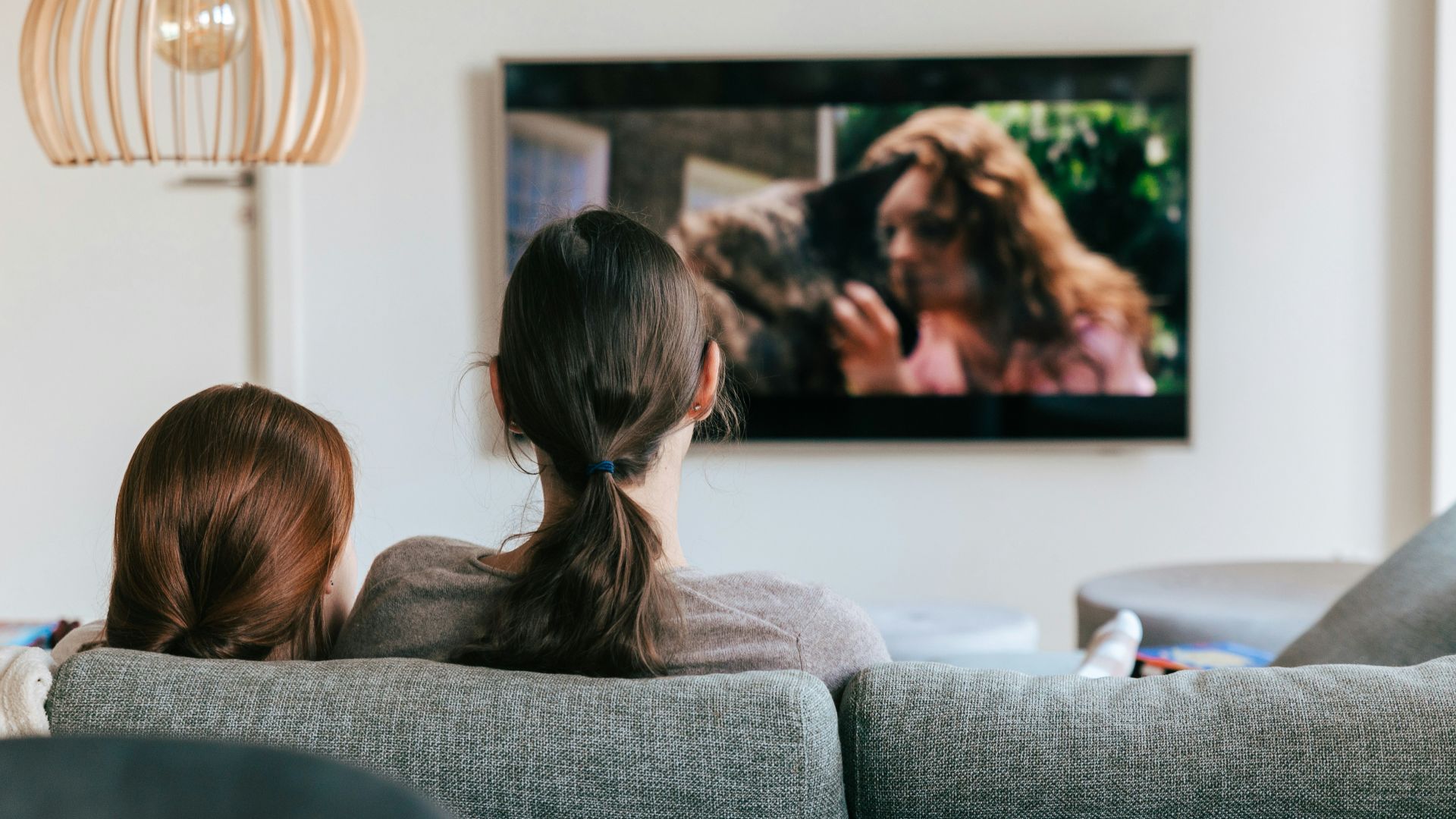 a couple of women sitting on top of a couch