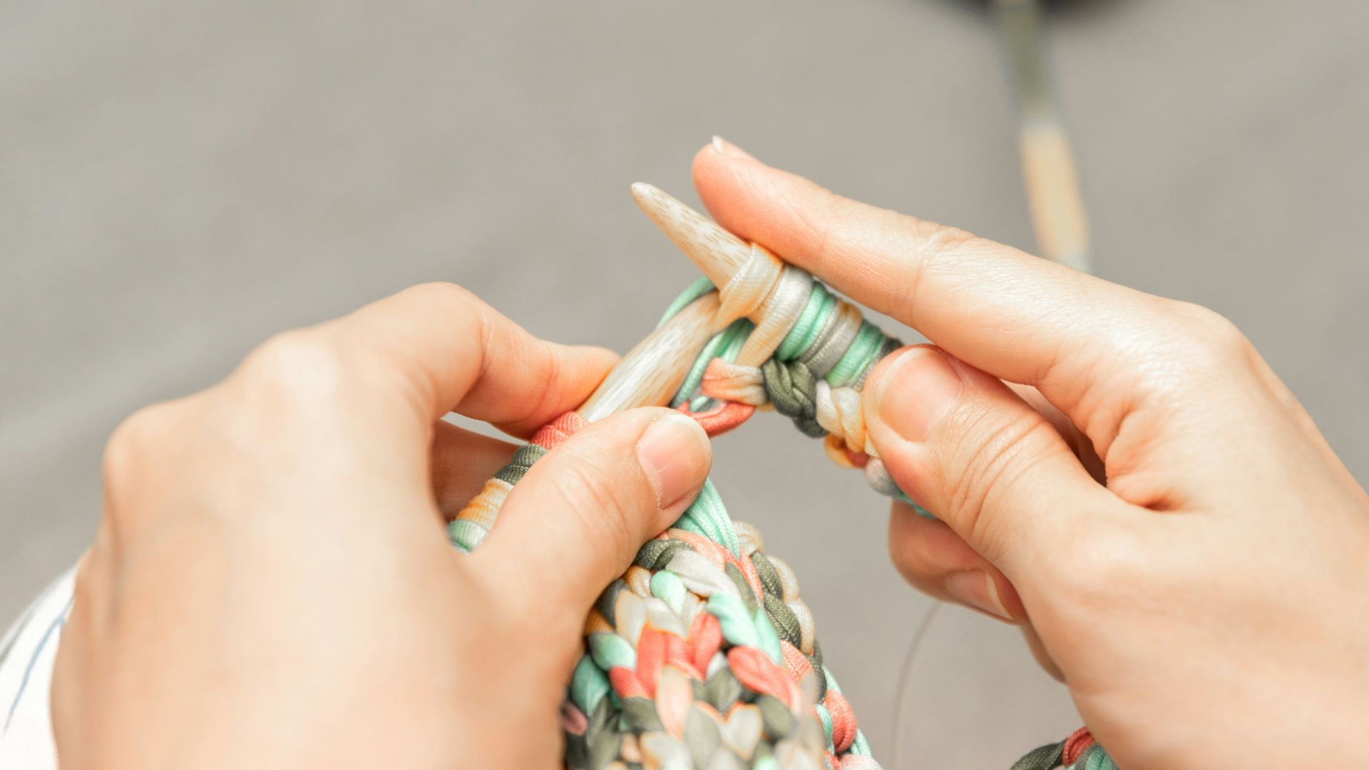 a woman is knitting a piece of fabric