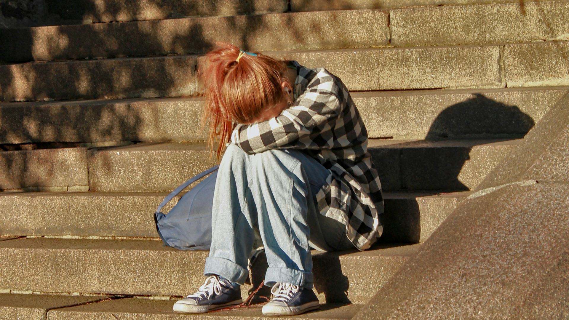 woman in black and white dress sitting on concrete stairs