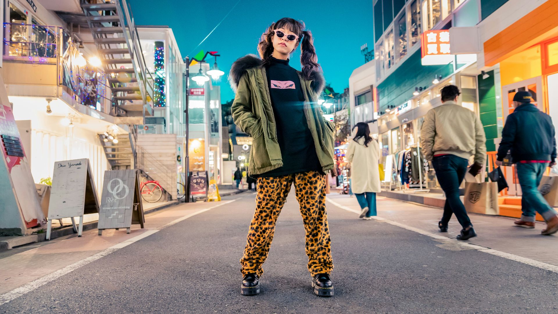 woman in green jacket stands and pose on street