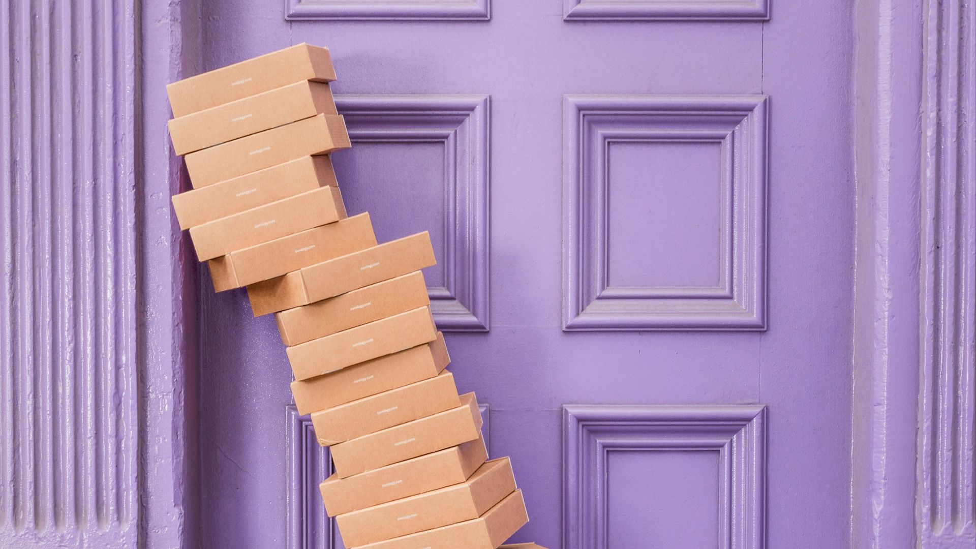 pile of brown boxes beside purple wooden wall