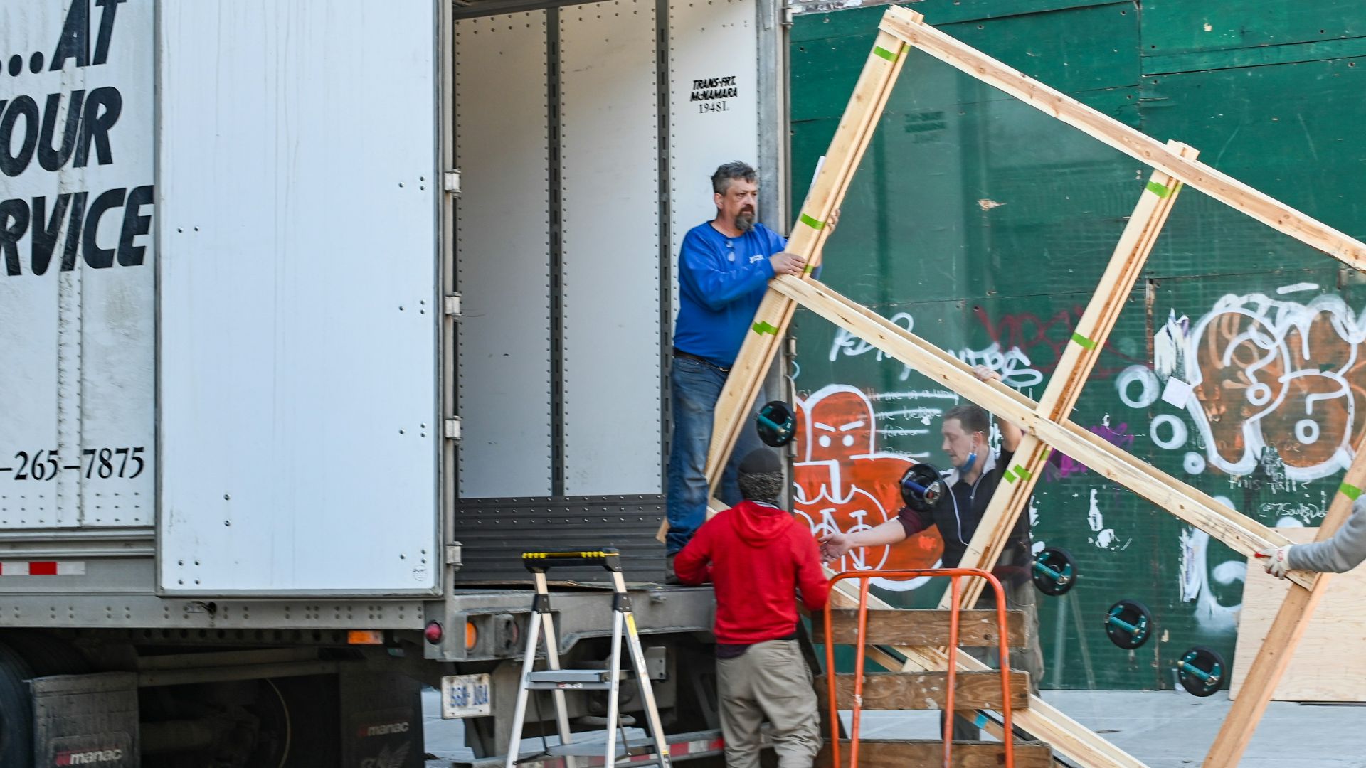2 boys in red shirt sitting on yellow metal bar