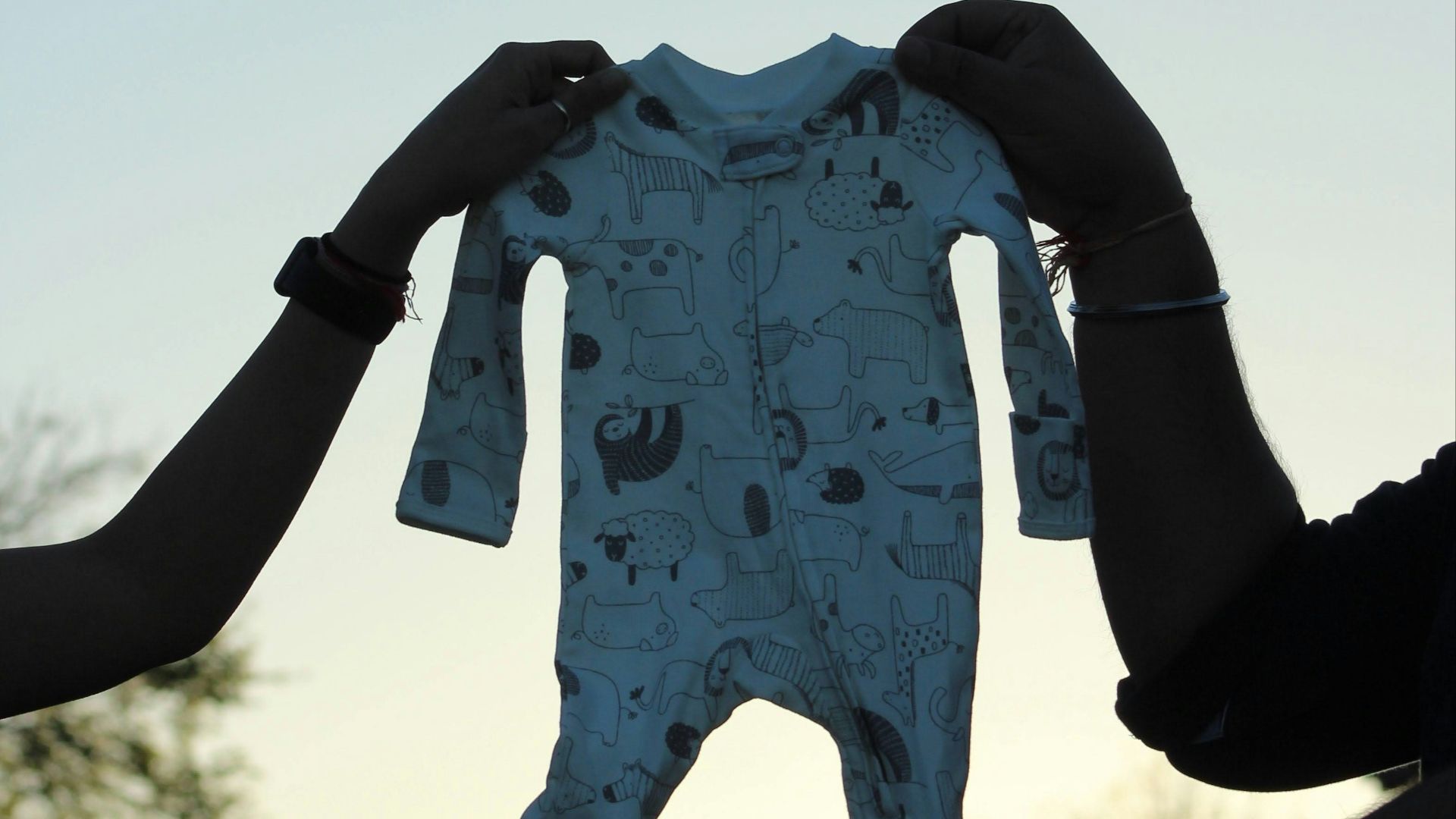 person in blue and white long sleeve shirt holding blue and white heart shaped balloon