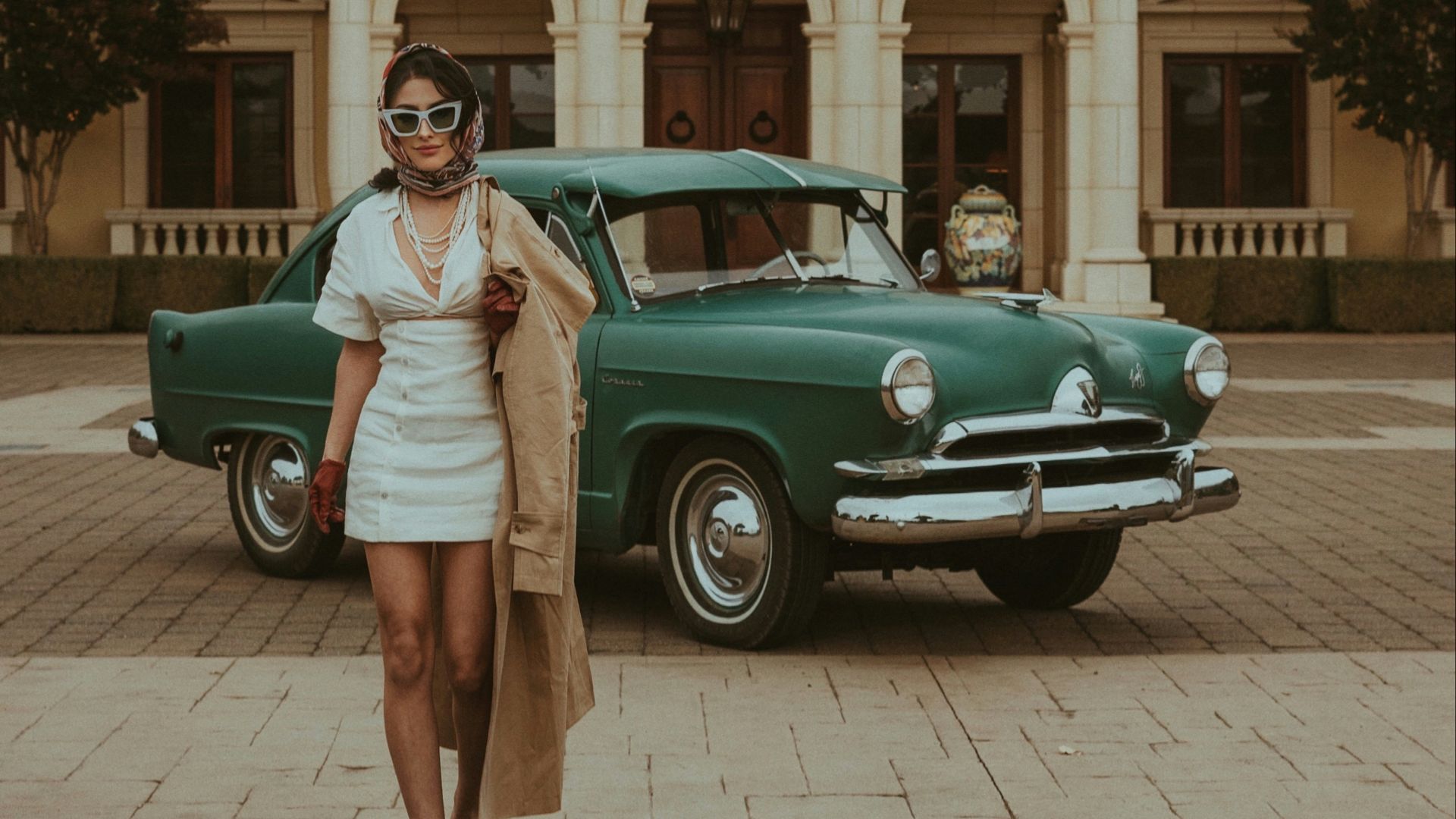 a woman standing in front of a green car