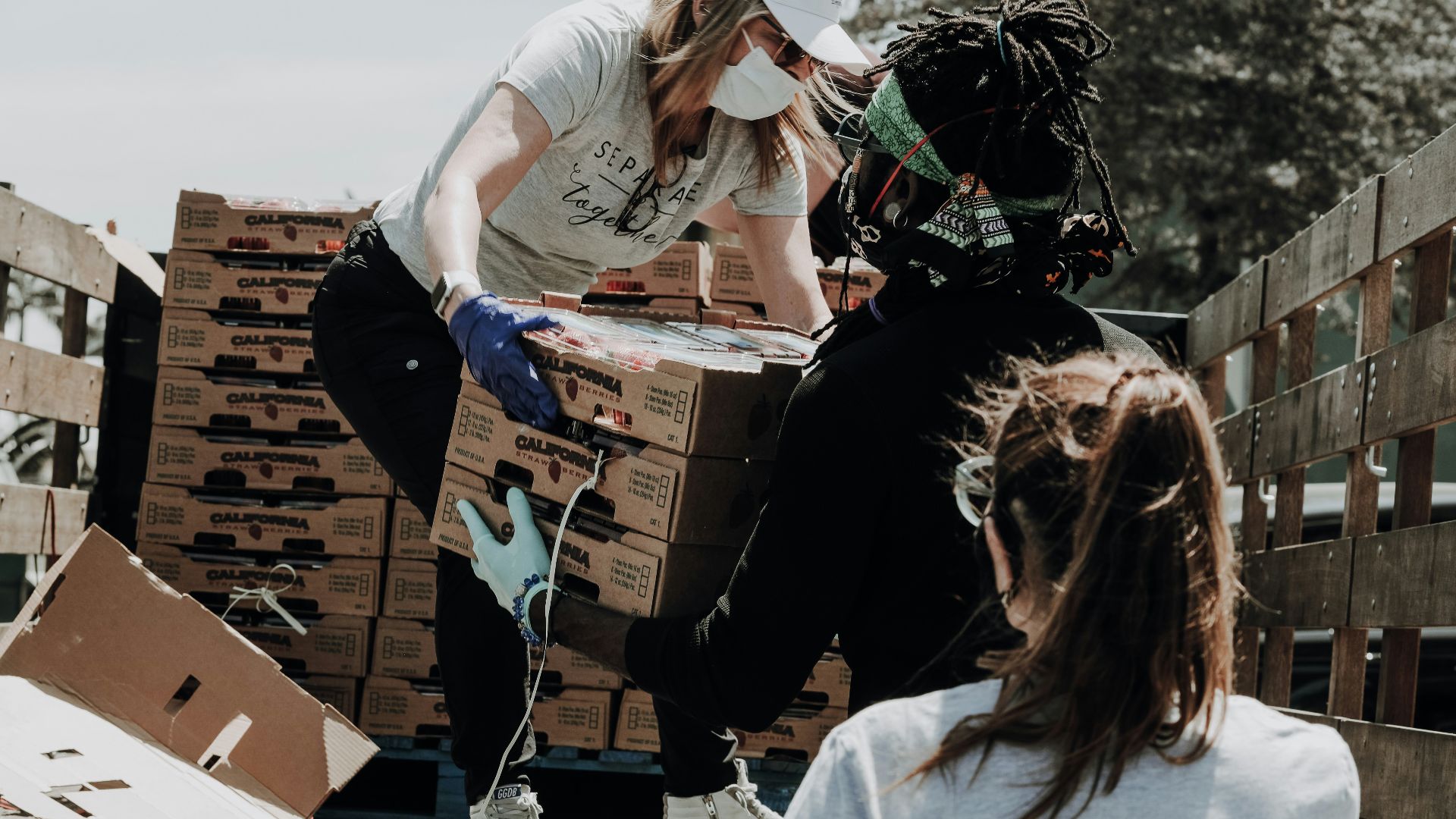 woman in white t-shirt and blue denim jeans sitting on brown cardboard box