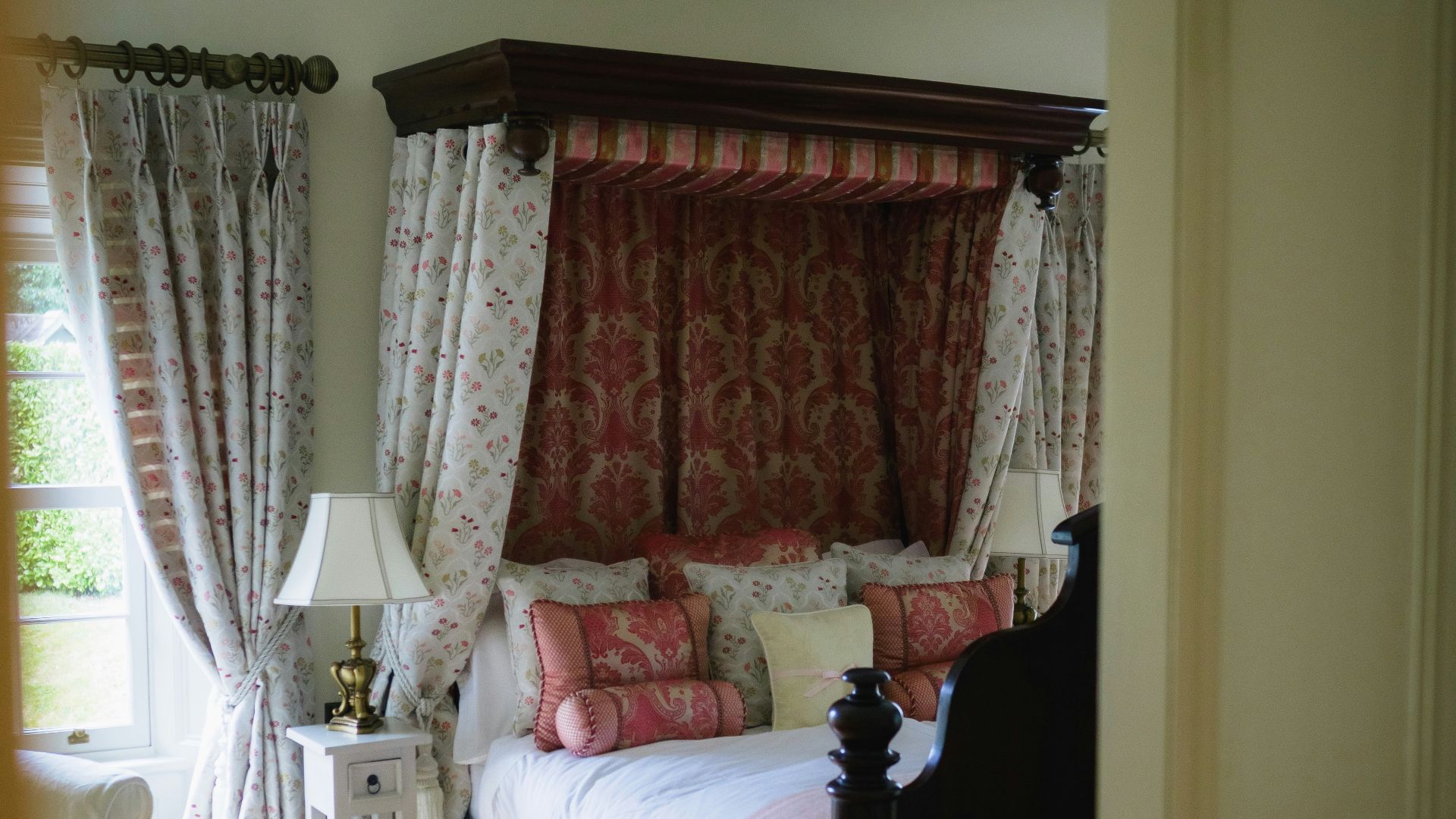 A luxurious bedroom with a four-poster bed and ornate curtains.