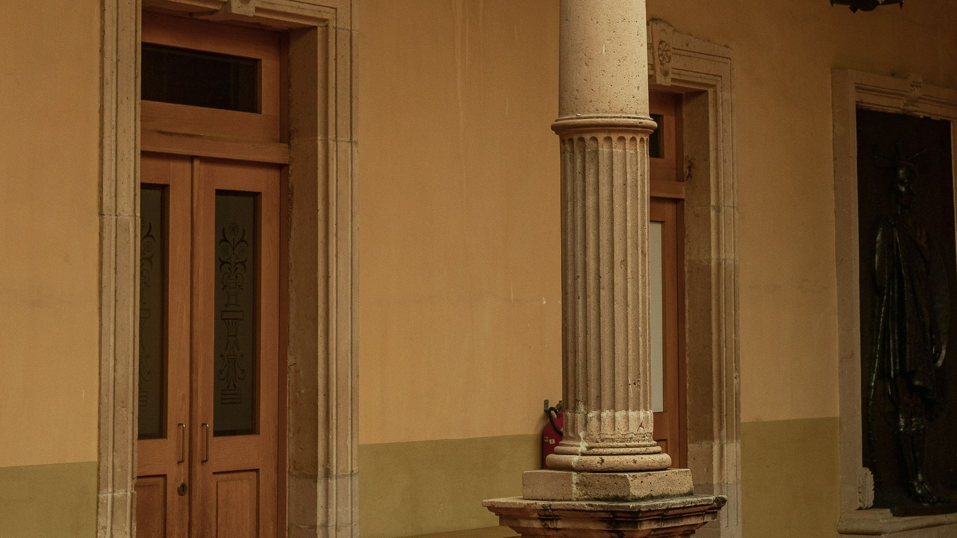 a tall pillar in a room with a door